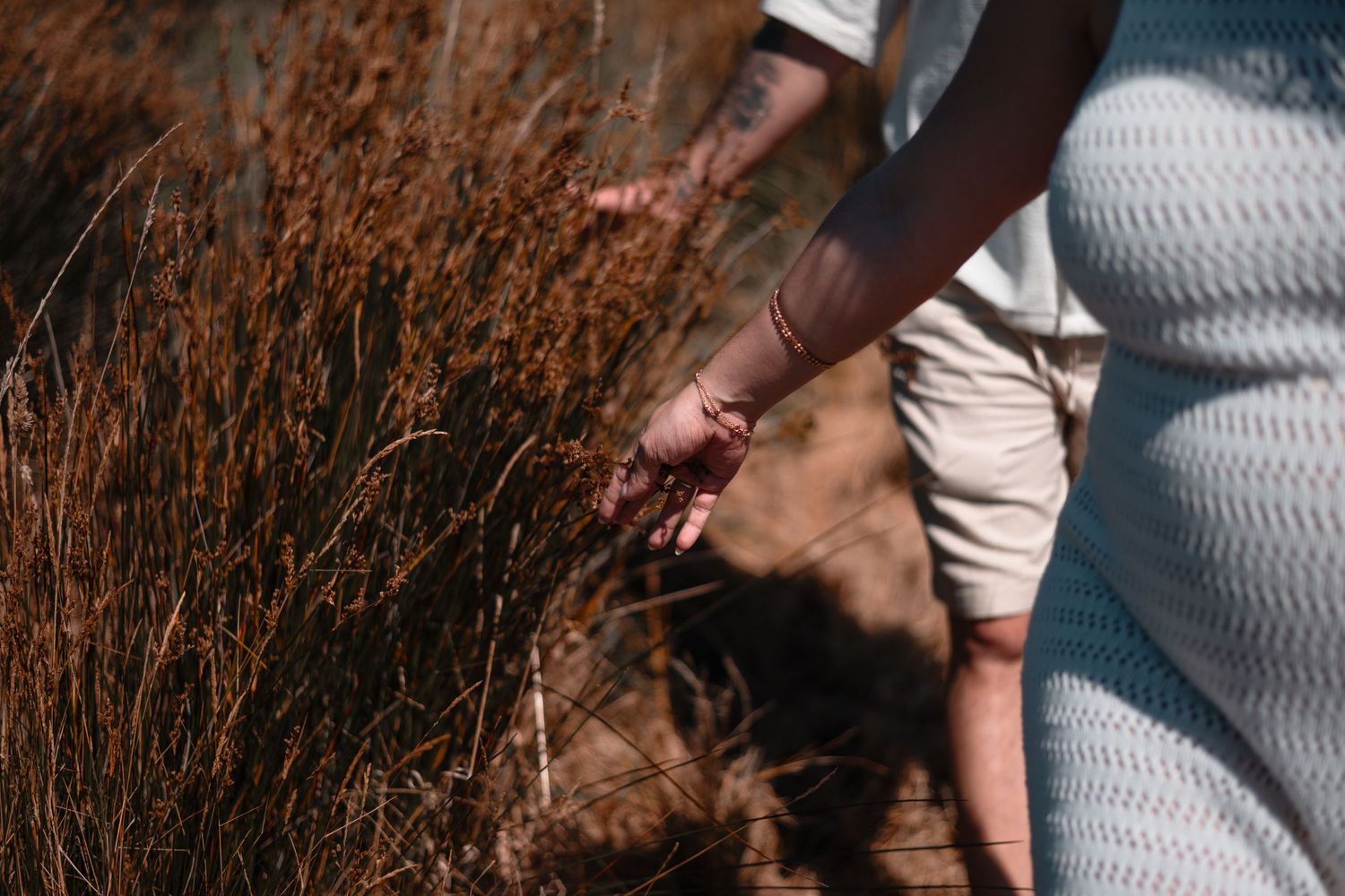 Intimate moments photographed in golden light against natural brush landscape.