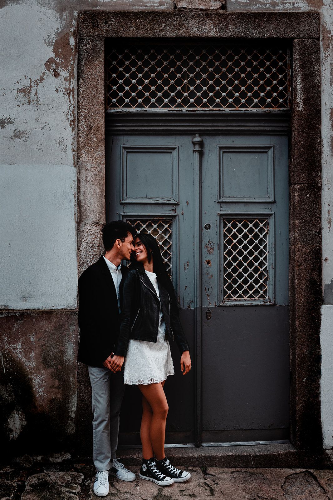 Romantic urban scene against vintage blue doors and weathered wall.