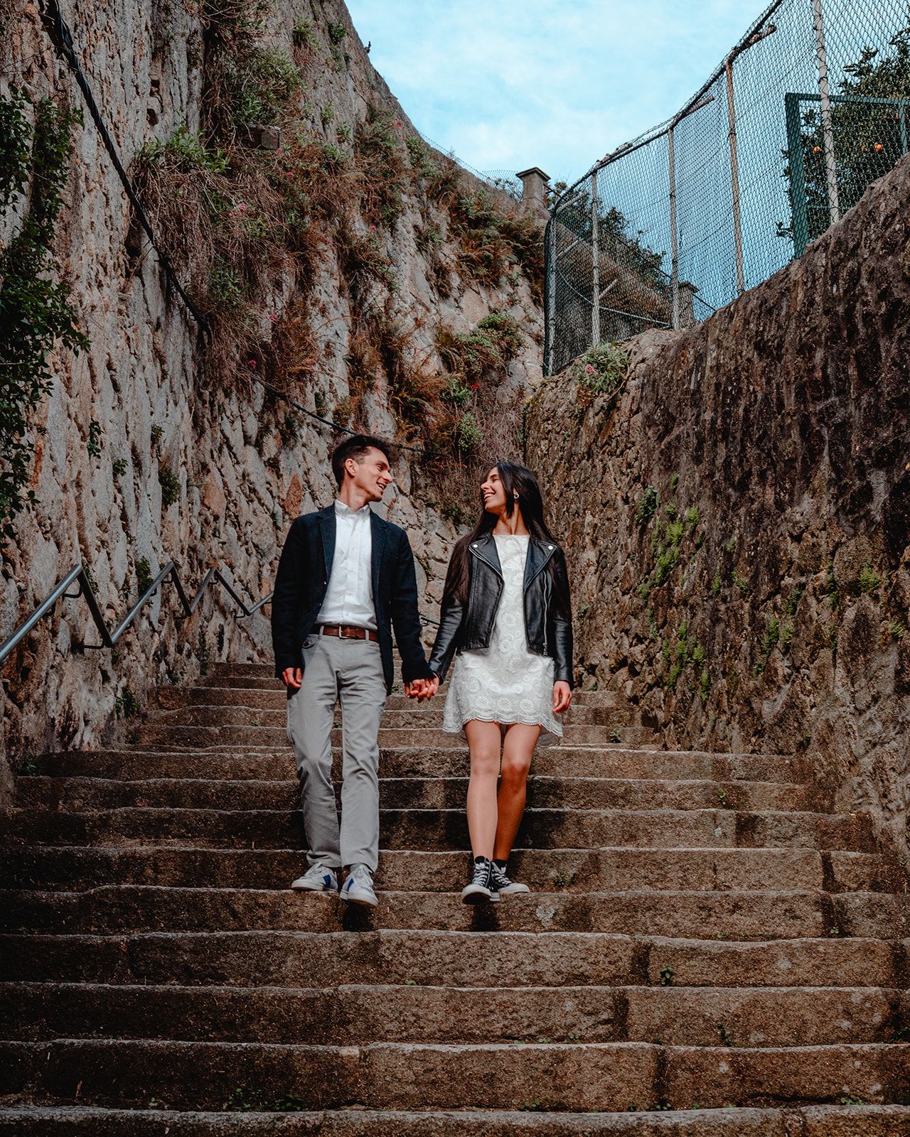 Urban photoshoot on ancient stone stairway surrounded by weathered walls.