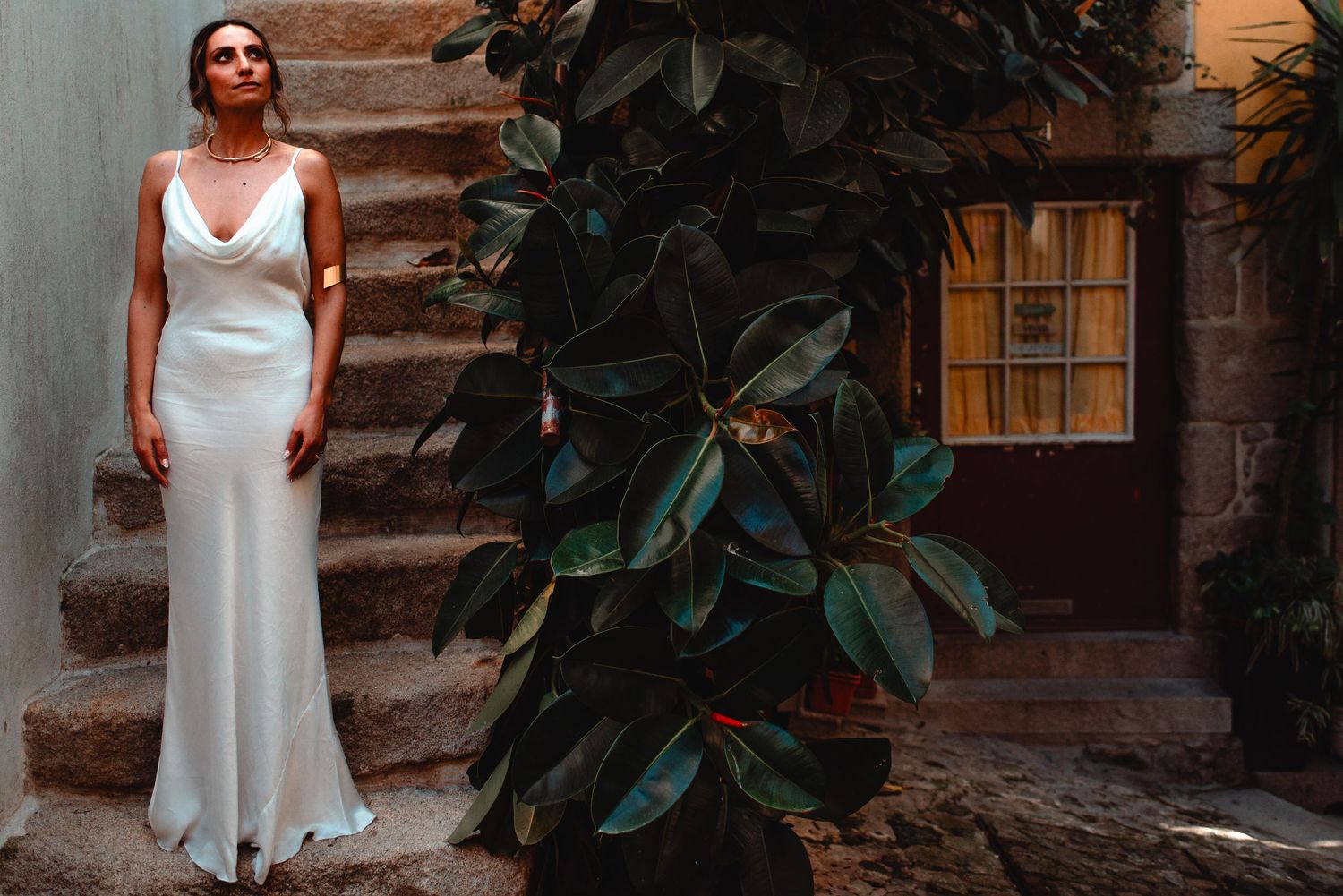 White-clad figures pose elegantly among tropical foliage on weathered stone steps.