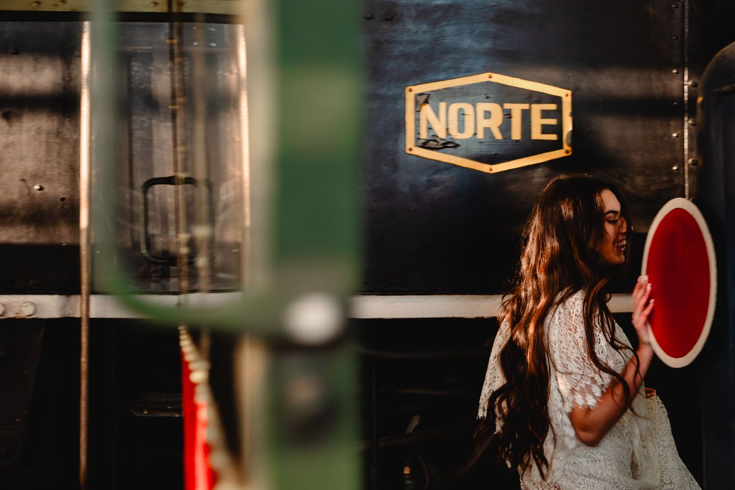 Artistic railway station shoot featuring vintage signs and white lace dress.