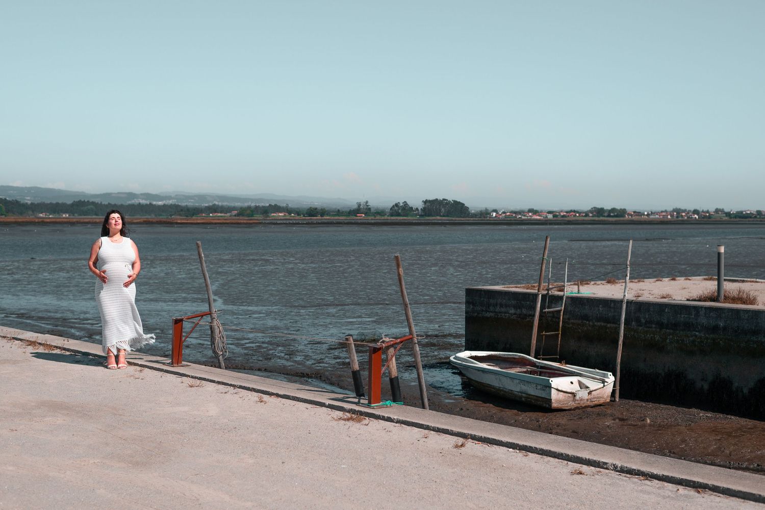 White boat docks extend into calm blue waters under clear skies.