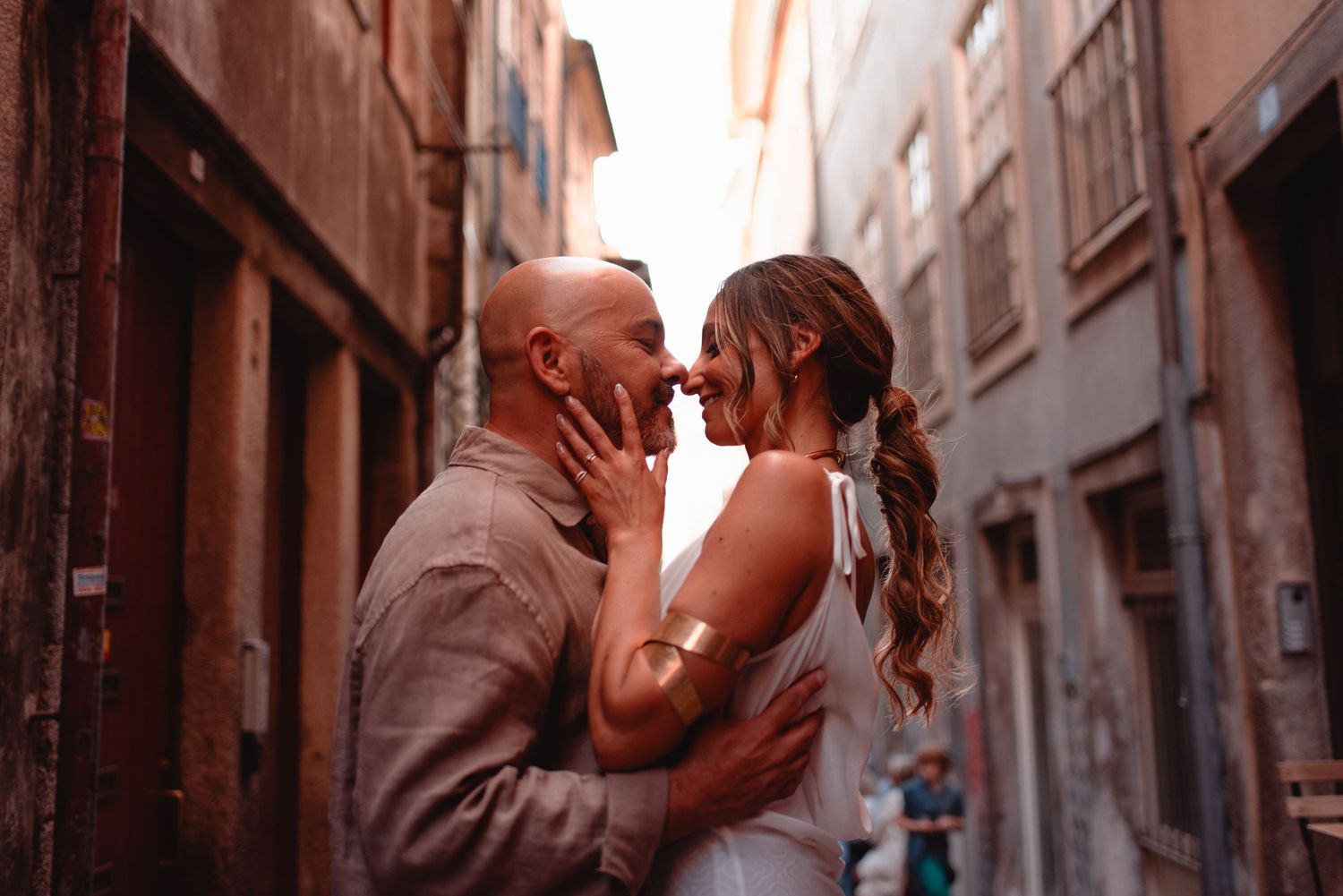 A tender moment between a couple in an intimate alleyway setting.