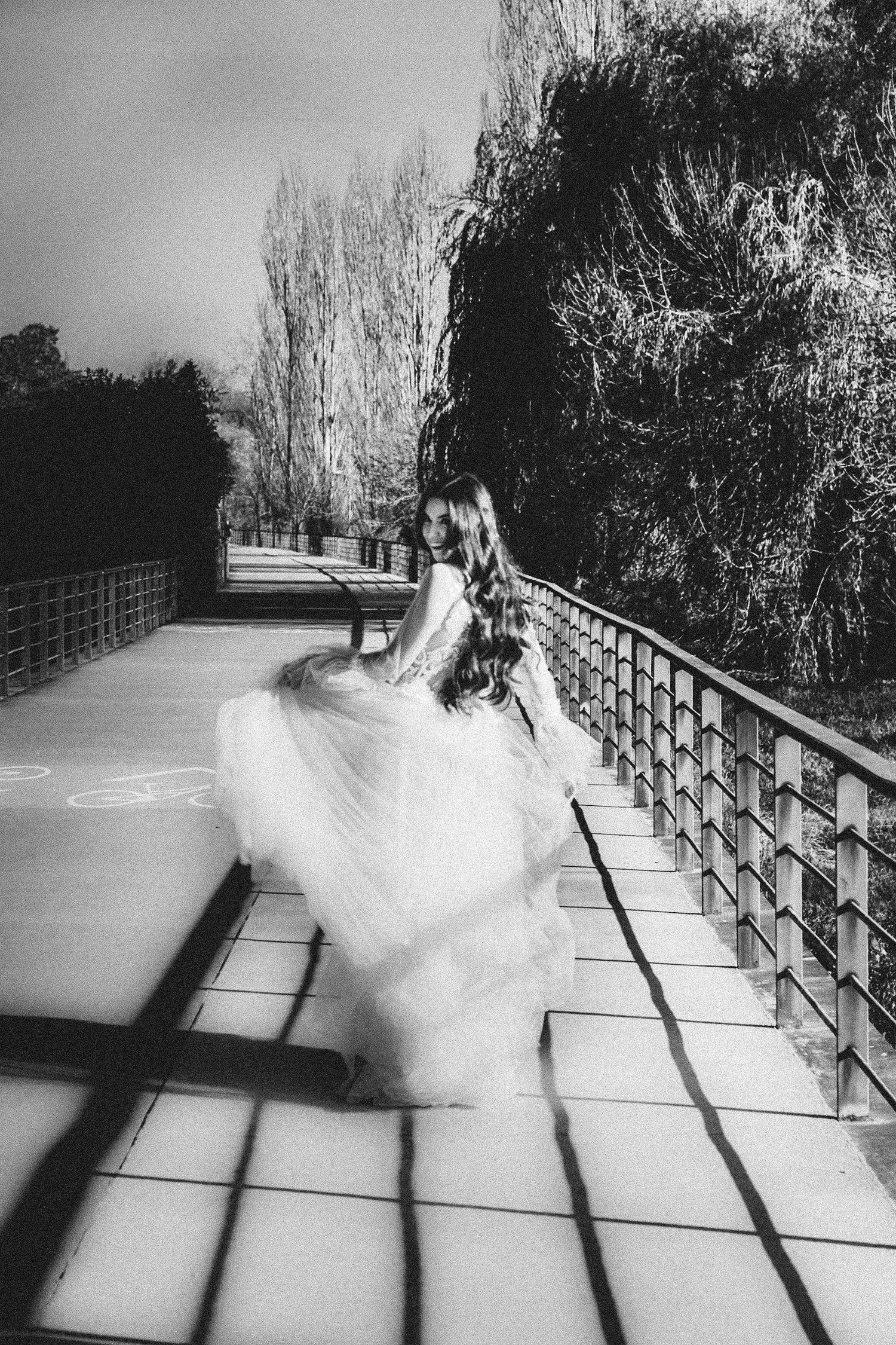Black and white artistic shots of a flowing wedding dress on a sunlit pathway.