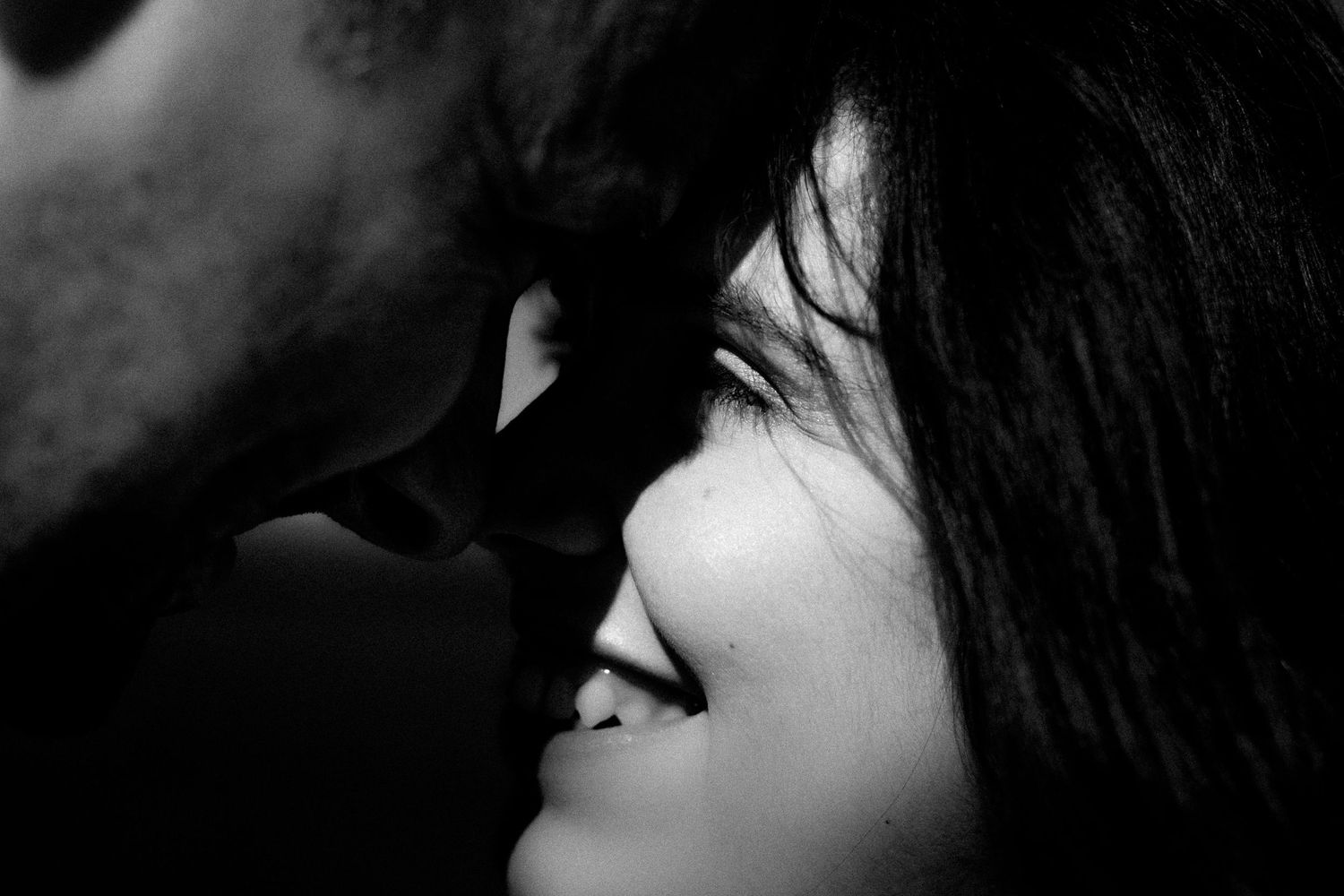 Black and white intimate close-up of couple sharing romantic moment.