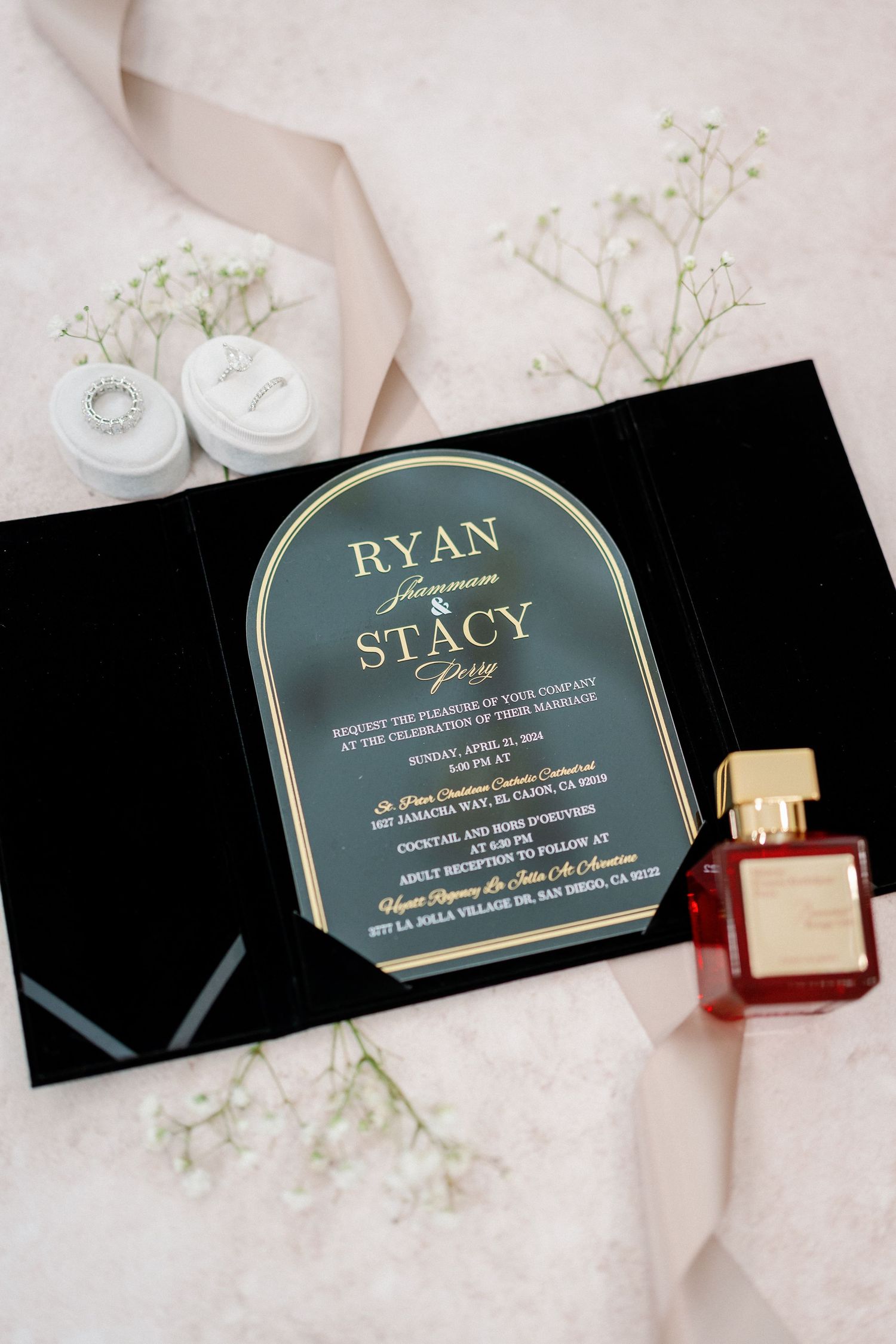 Wedding invitation cards in dark green with gold text and delicate floral accents.