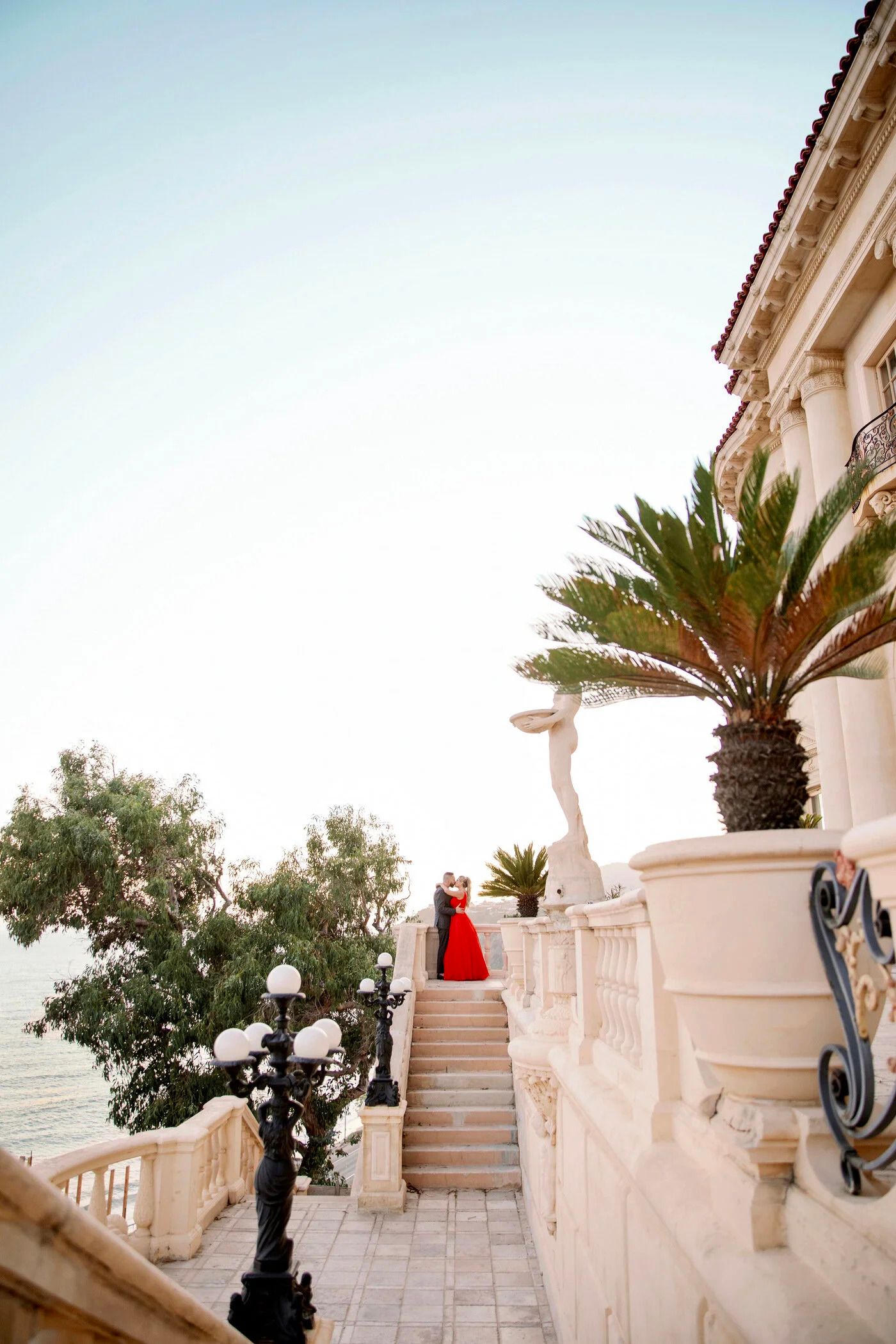 Elegant outdoor staircase with palm trees and Mediterranean architectural details at a luxury venue.