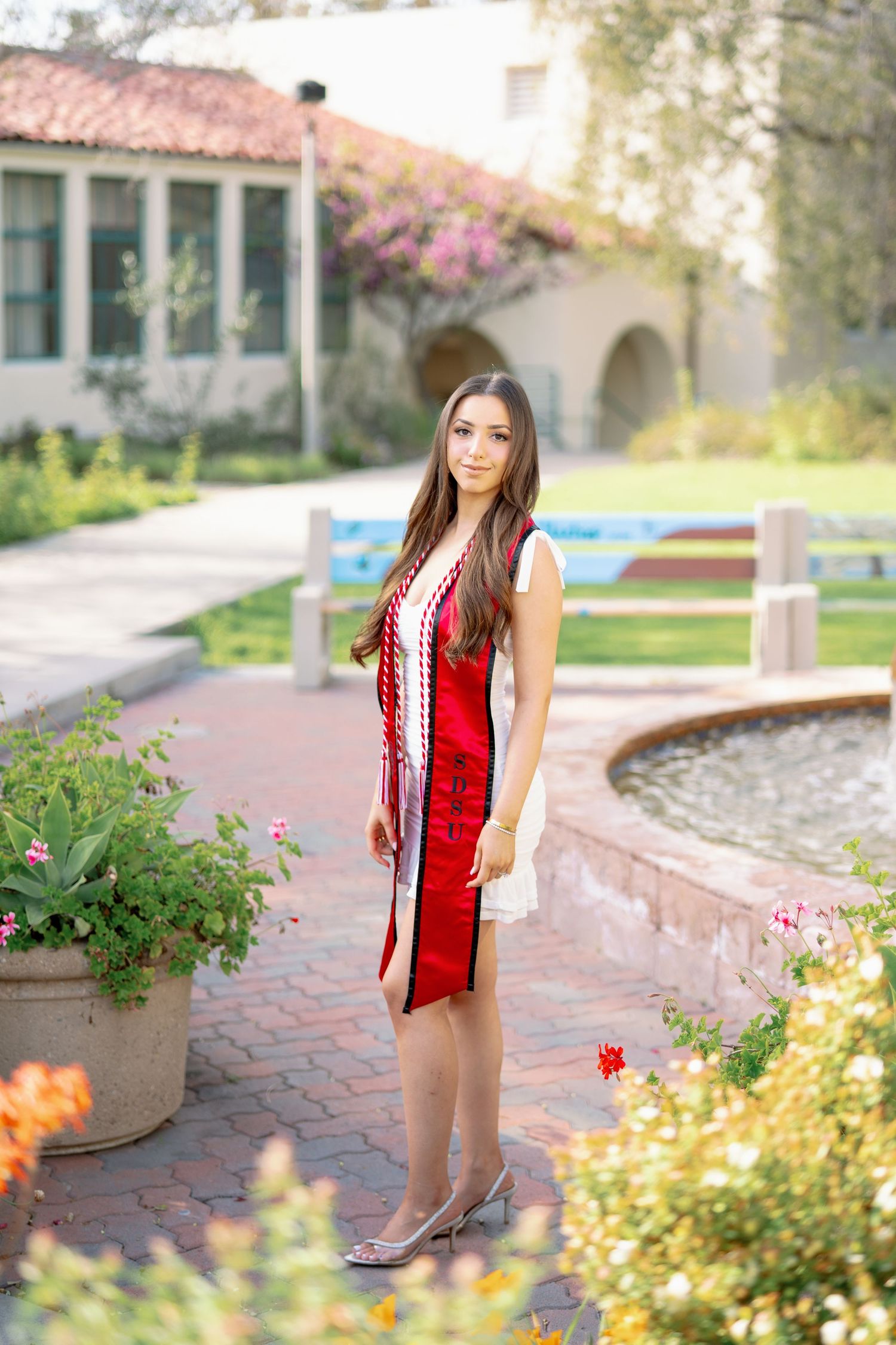 Portrait series on brick pathways with Spanish architecture and flowering gardens in background.