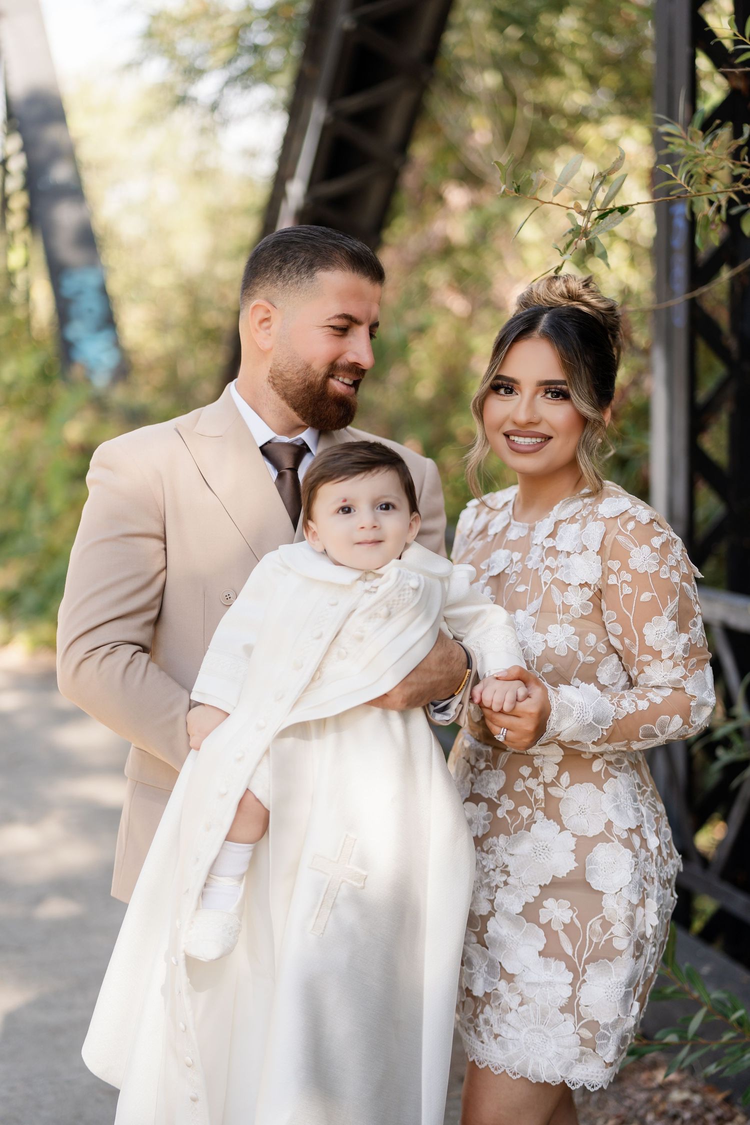 A series of wedding photos showing tender moments between a couple and child in elegant white attire outdoors.