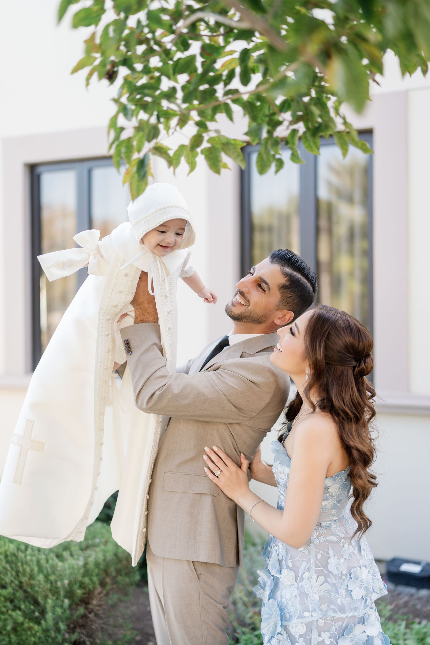 A joyful couple in wedding attire share playful moments together in an outdoor garden setting.