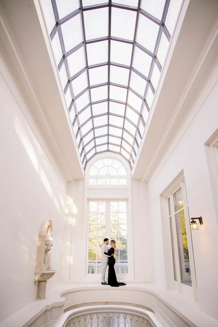 Elegant interior with arched glass ceiling and white walls creates dramatic lighting.