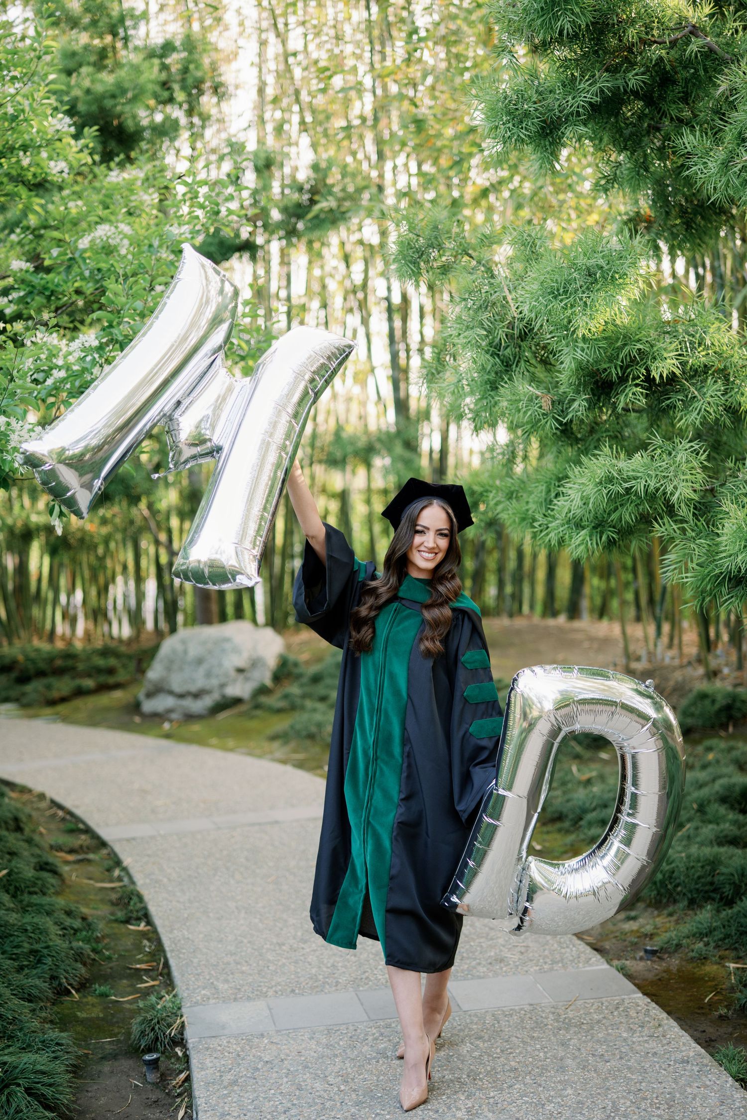 Graduation photos in a wooded setting with silver letter balloons and academic regalia.