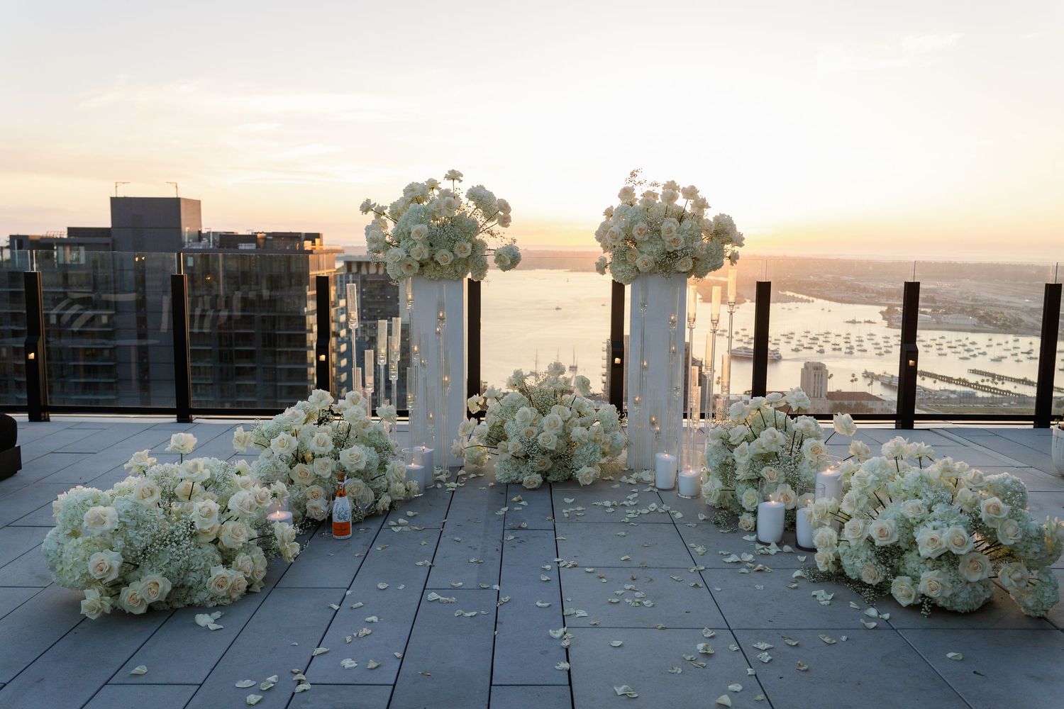 White floral arrangements and pillars create an elegant outdoor display.