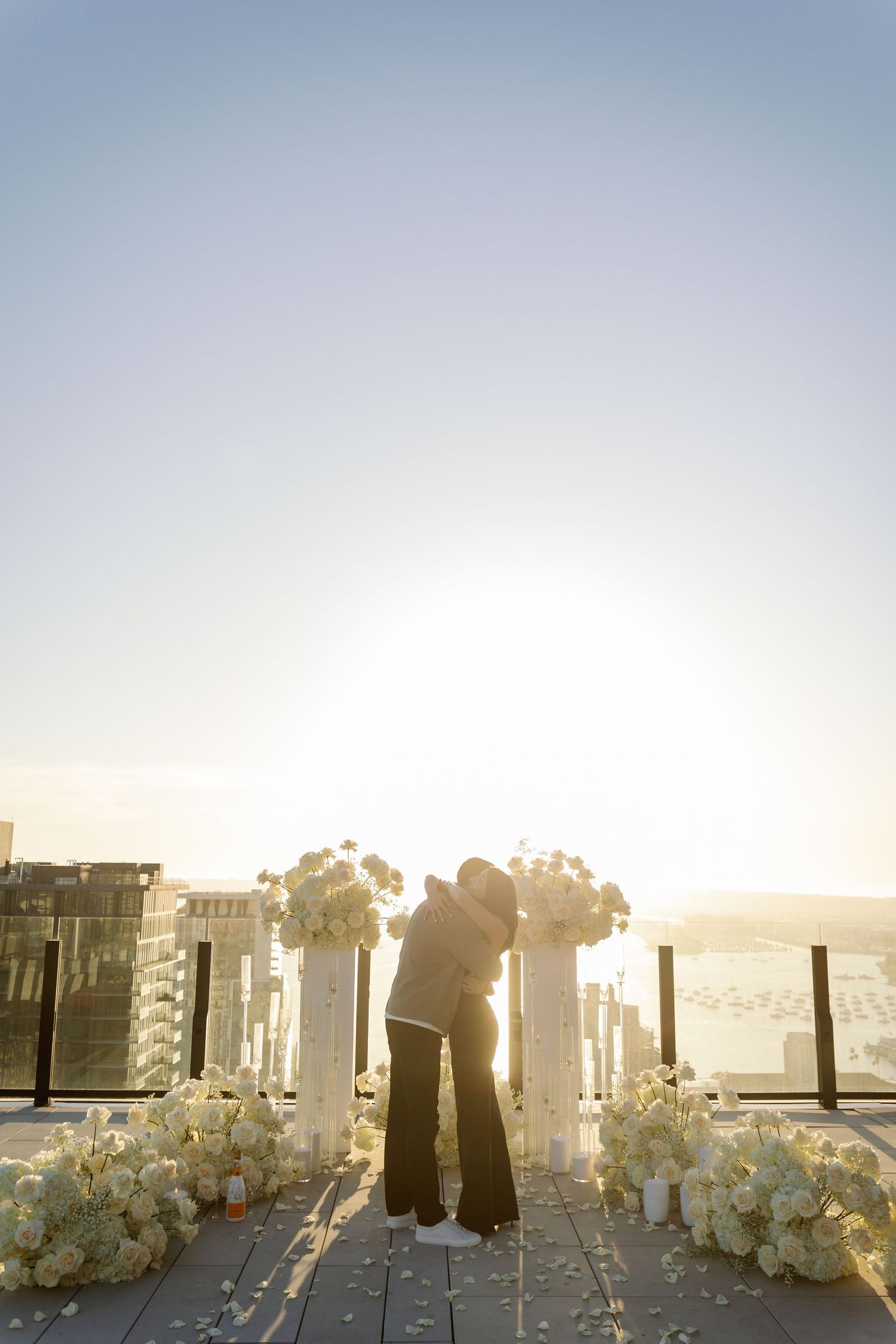 White floral arrangements and pillars create an elegant outdoor setting at sunset.
