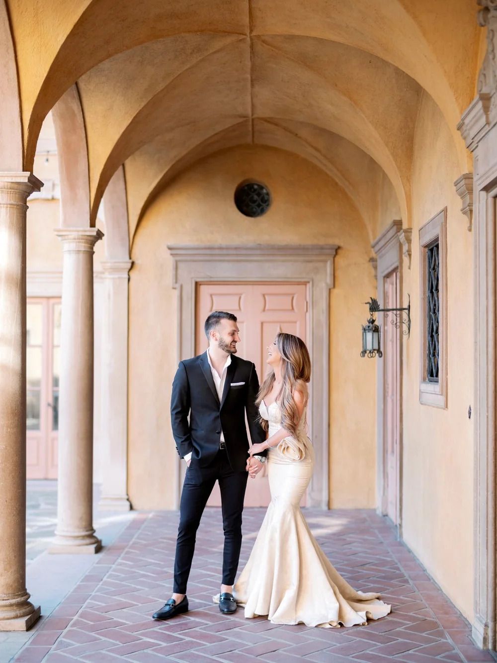 Elegant arched colonnade with peach-colored walls and terracotta flooring creates romantic ambiance.
