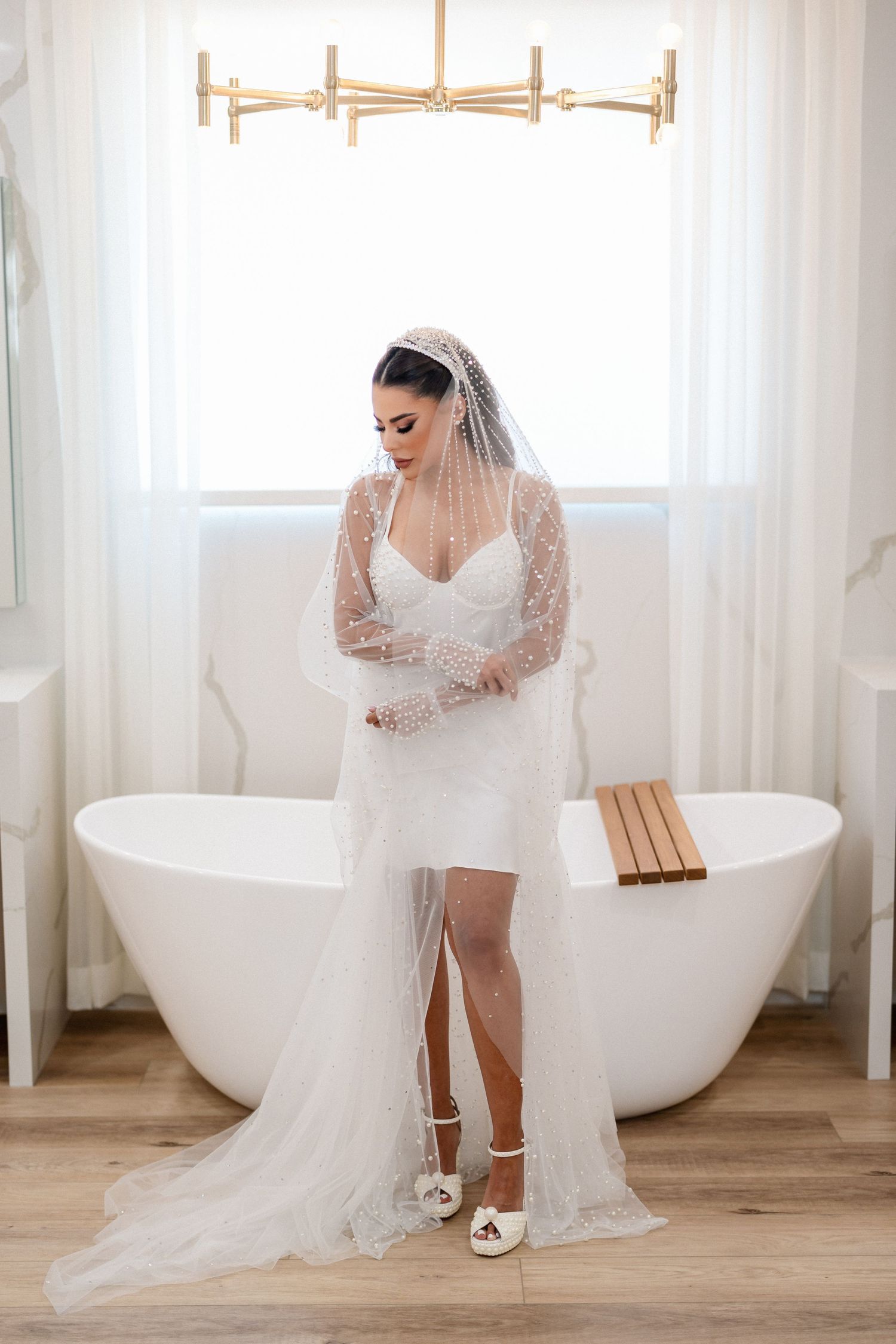 Bridal portraits in a minimalist white room with a freestanding bathtub.