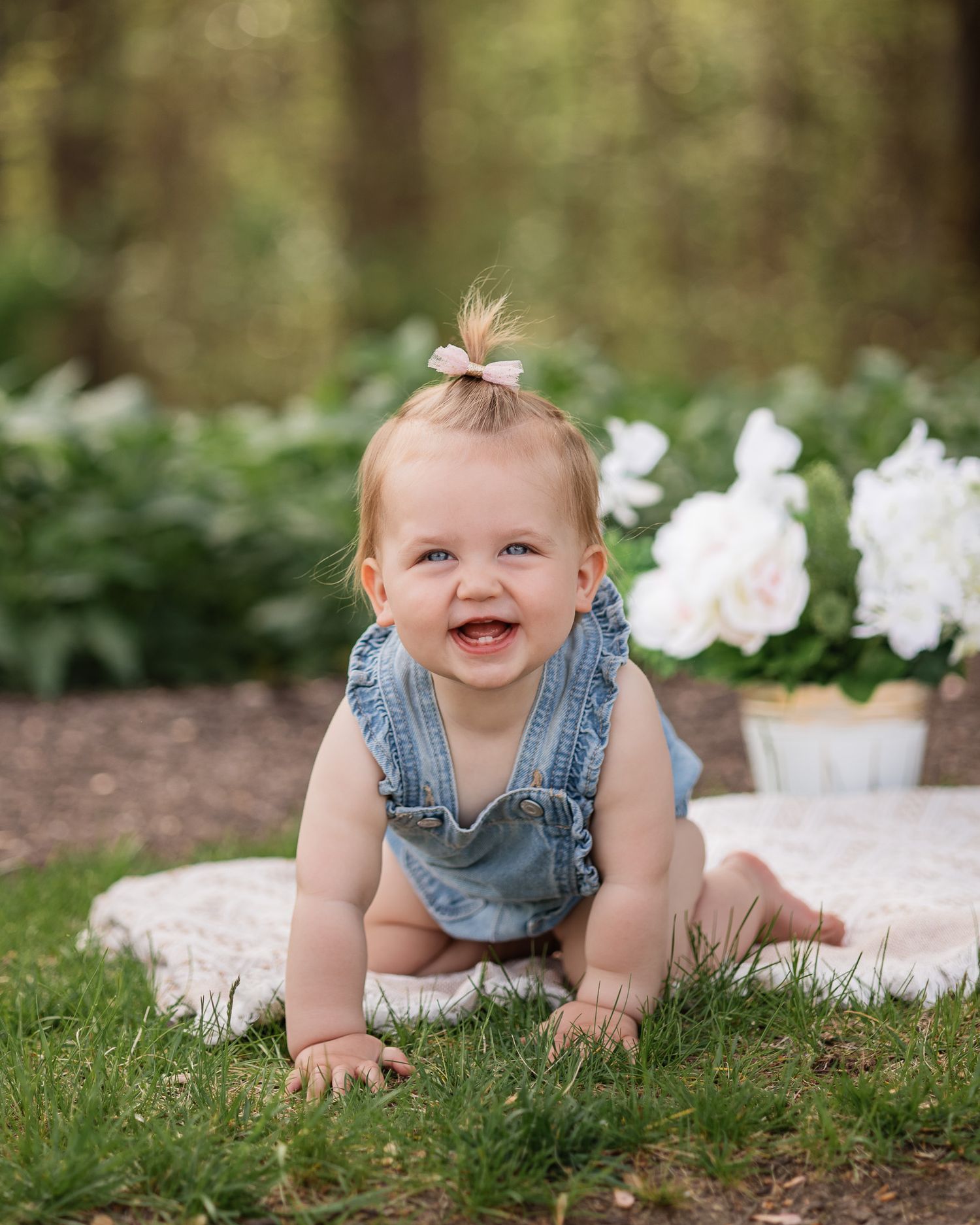 Toddler on a blanket crawling and smiling at the camera