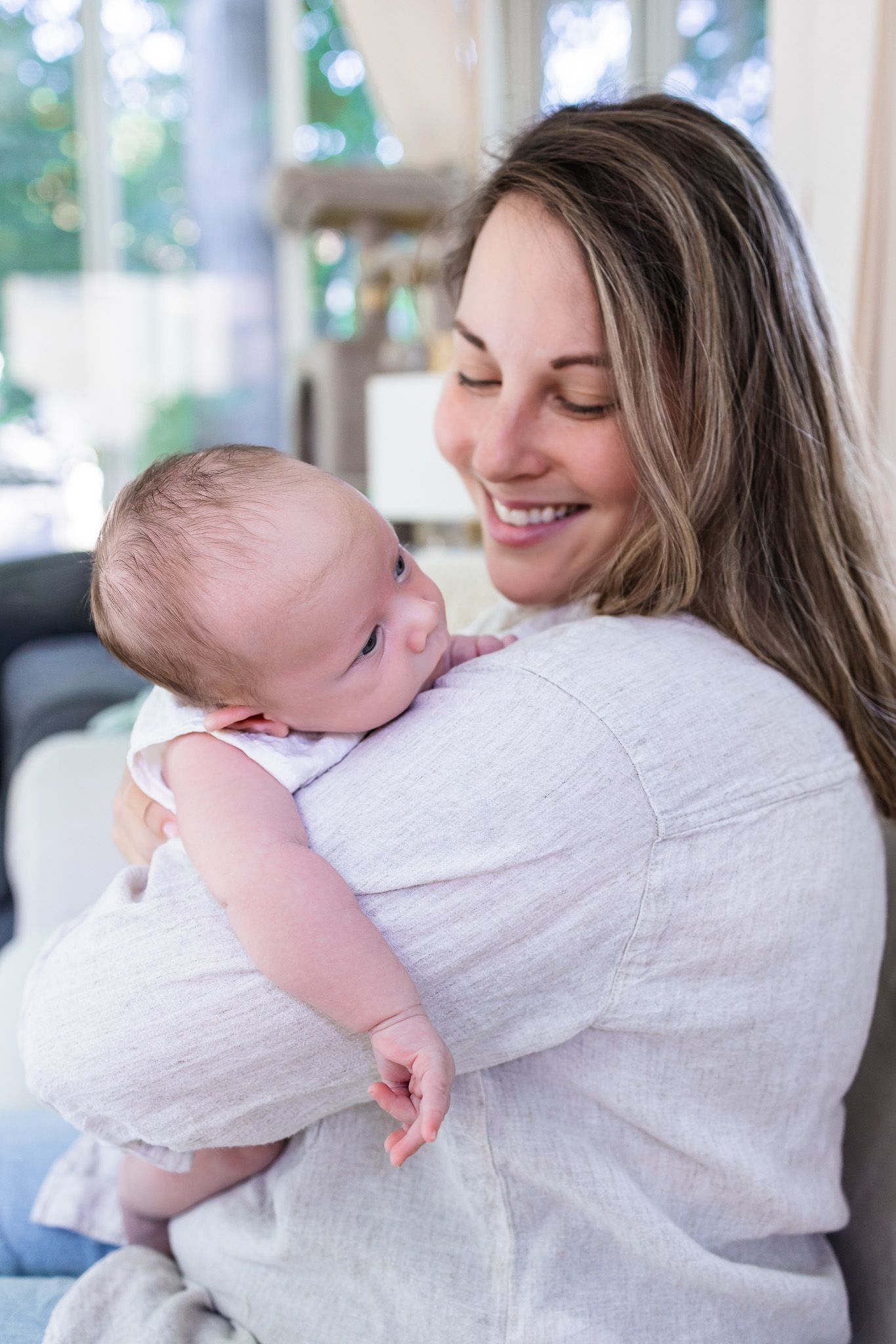 Mom holding her newborn during an in-home photography session.