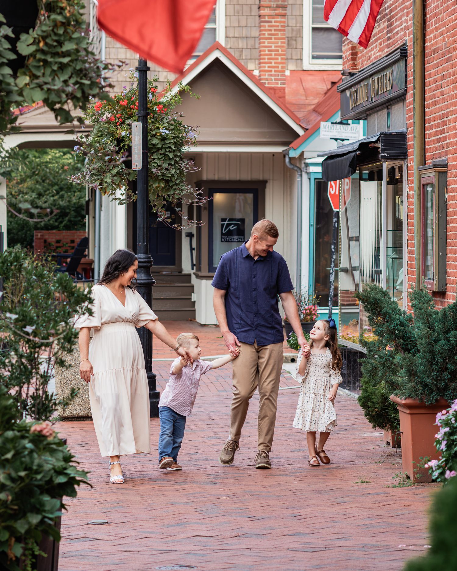 Family walking in historic downtown Annapolis holding hands.