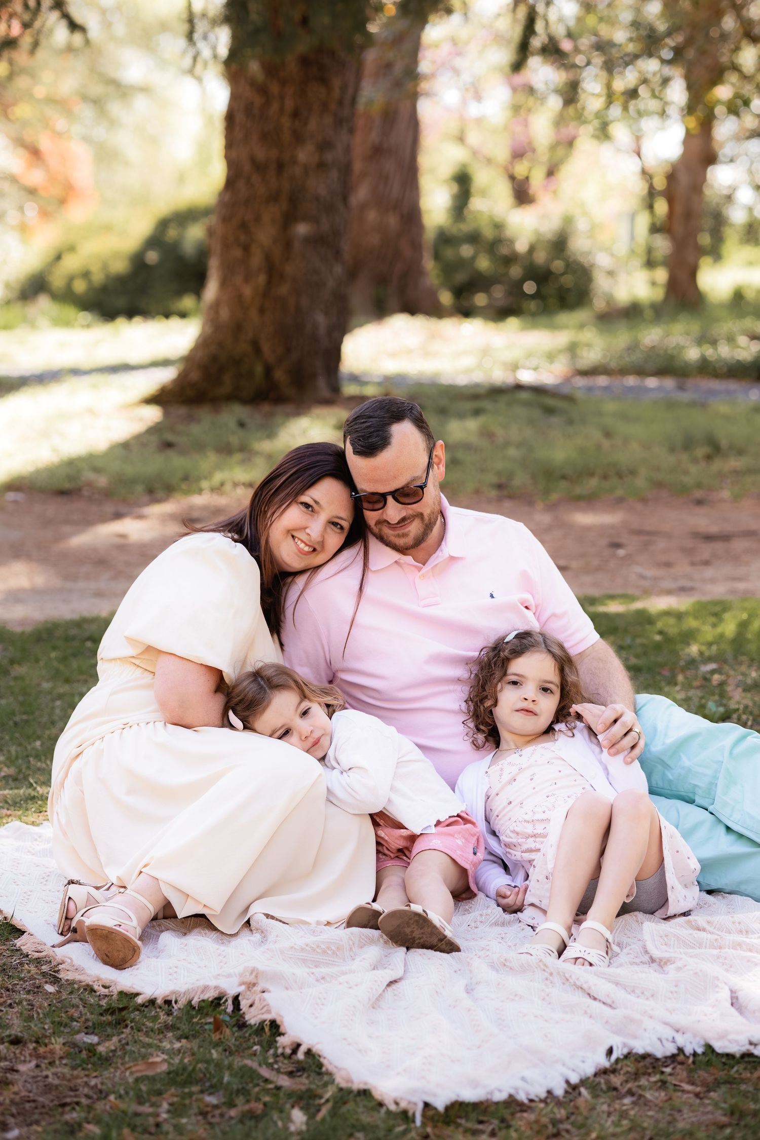 A family sitting on a blanket in the grass for a spring family photo in Crofton Maryland