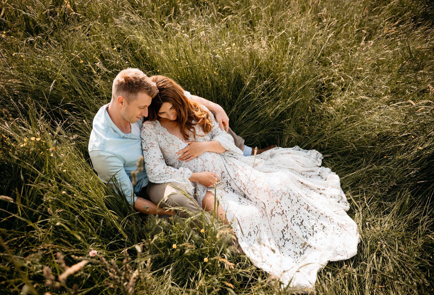 Paar beim Babybauchshooting in wiese fotografiert