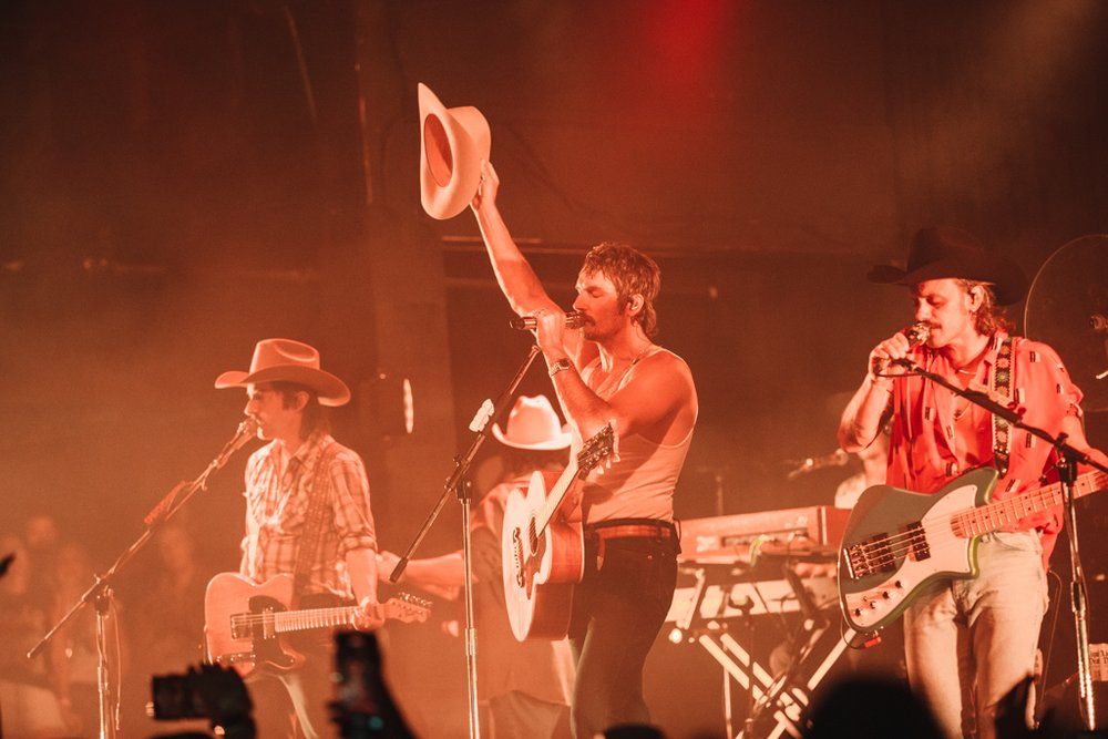 Band members Midland performing on stage with warm lighting and cowboy hats at Billy Bobs Texas