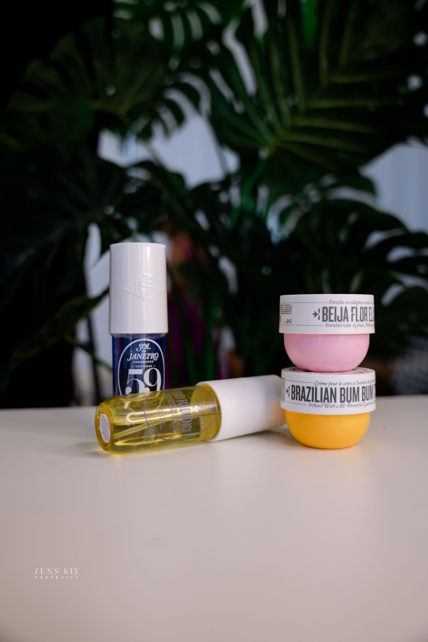 Skincare products including Jergens SPF 59, hair oil, Beija Flor and Brazilian Bum Bum cream on white surface.