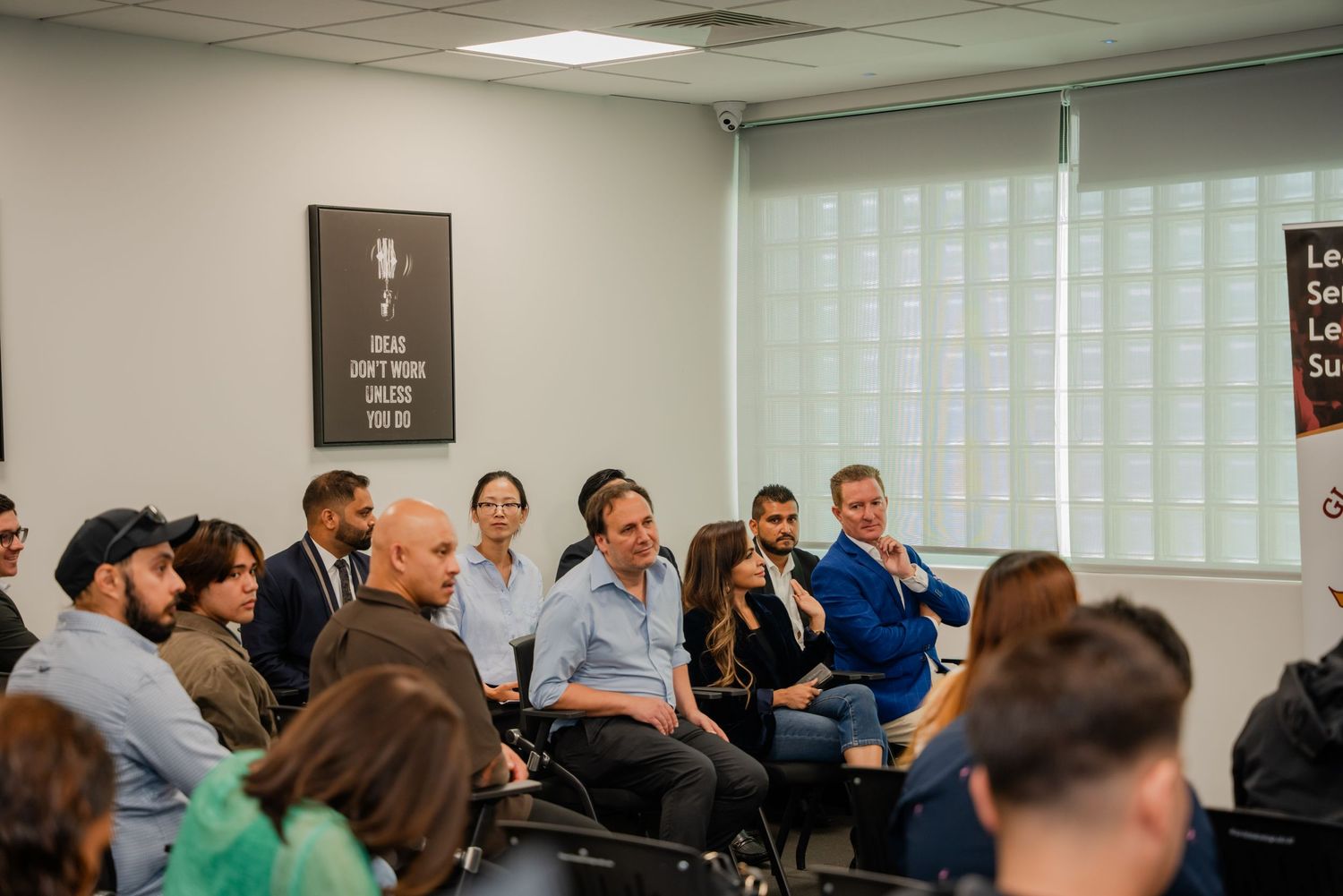 Group of professionals engaged in a business meeting or seminar in a modern conference room.