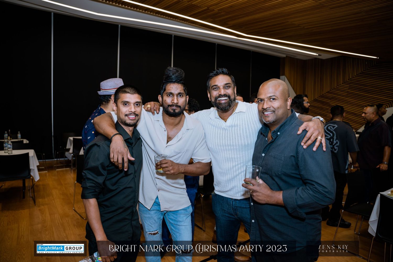 Four men smiling and posing together at the BrightMark Group Christmas Party 2023.
