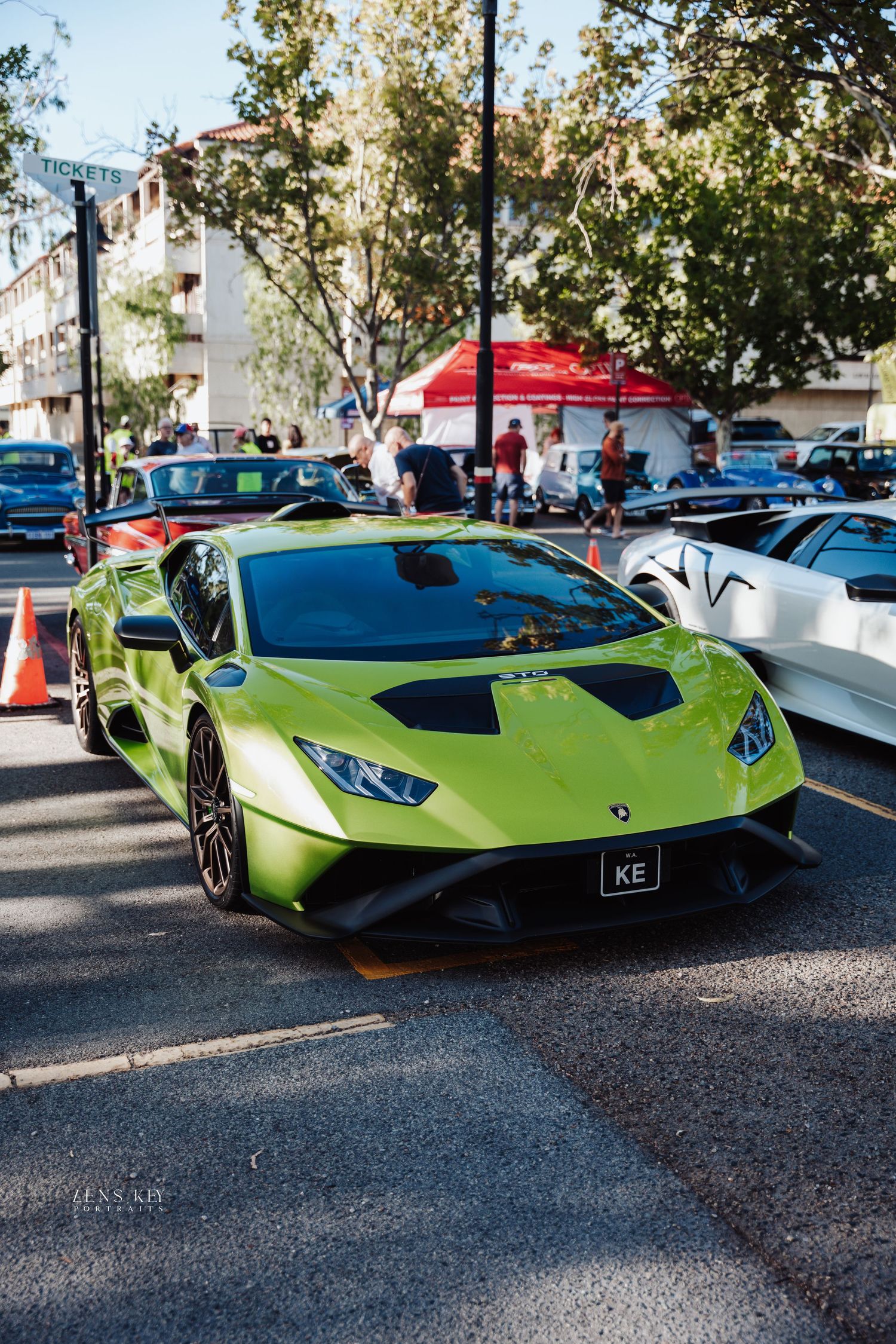 Bright green Lamborghini Huracan with KE plate displayed at outdoor exotic car show event.