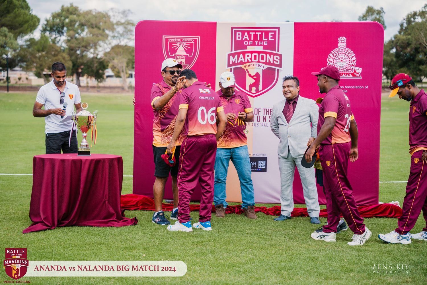 Cricket players in maroon uniforms receiving trophy at the 2024 Battle of the Maroons Big Match.