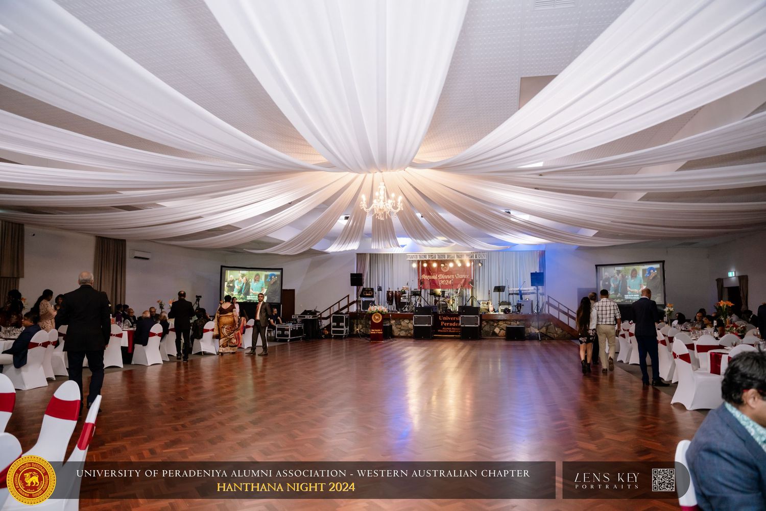 Elegant banquet hall with white draped ceiling and dance floor set up for a formal event.