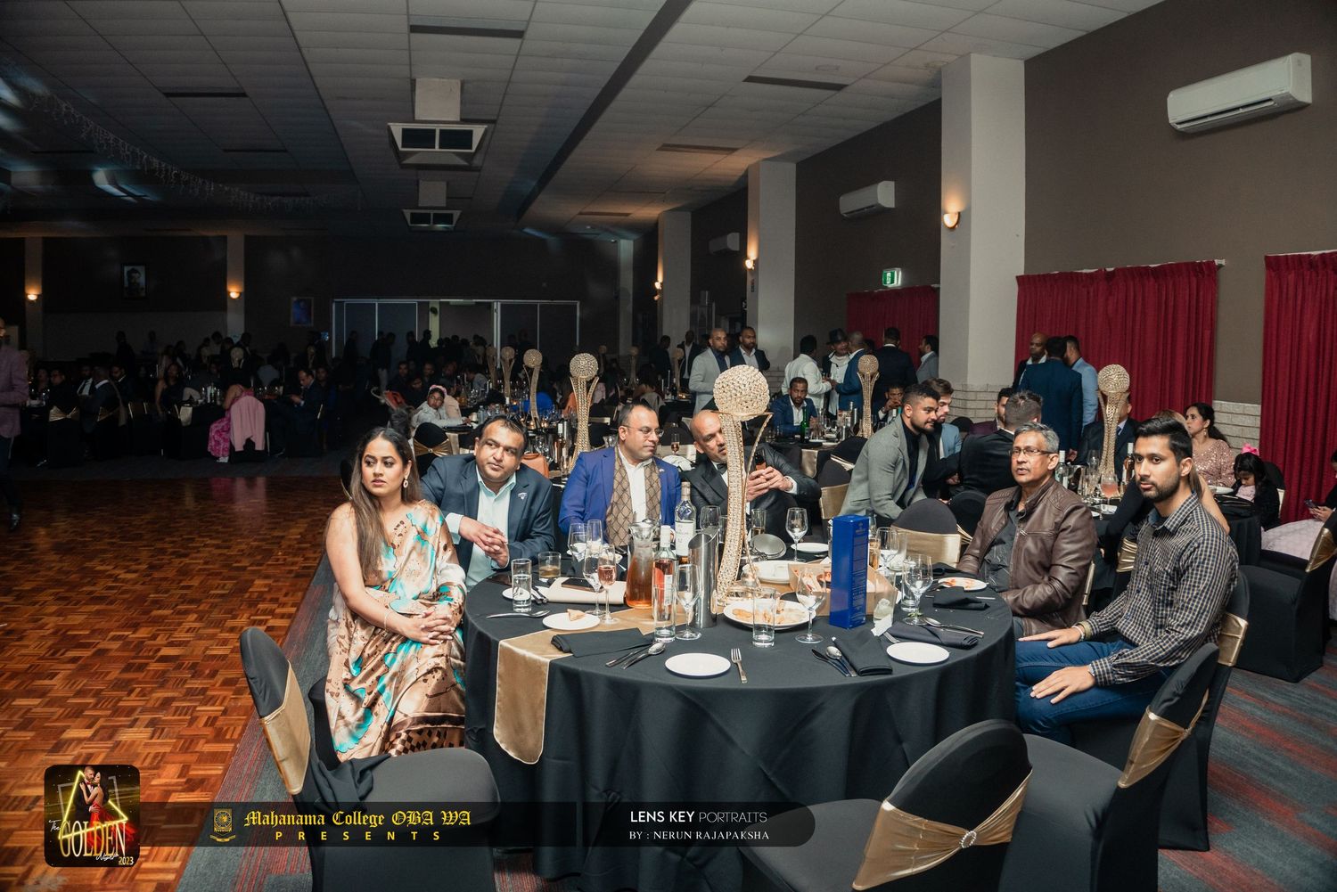 Guests seated at elegantly decorated tables during a formal South Asian banquet event.