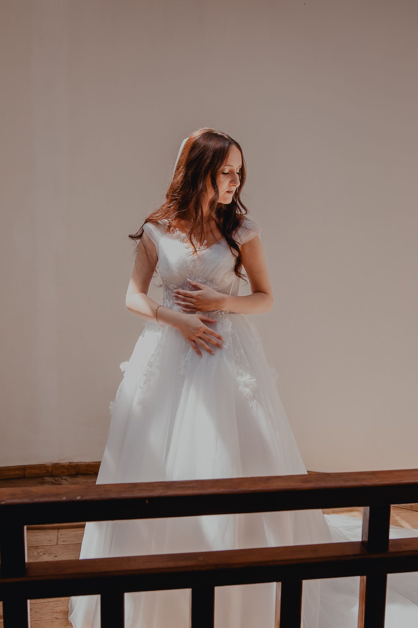 Person in flowing white wedding dress twirling on wooden platform.