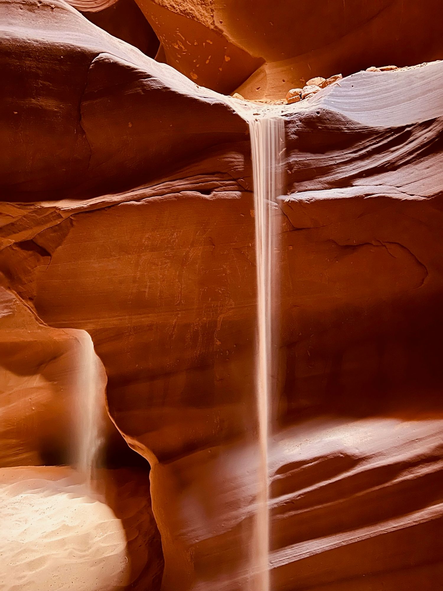 Light beams streaming through slot canyons creating dramatic patterns in the red sandstone walls.