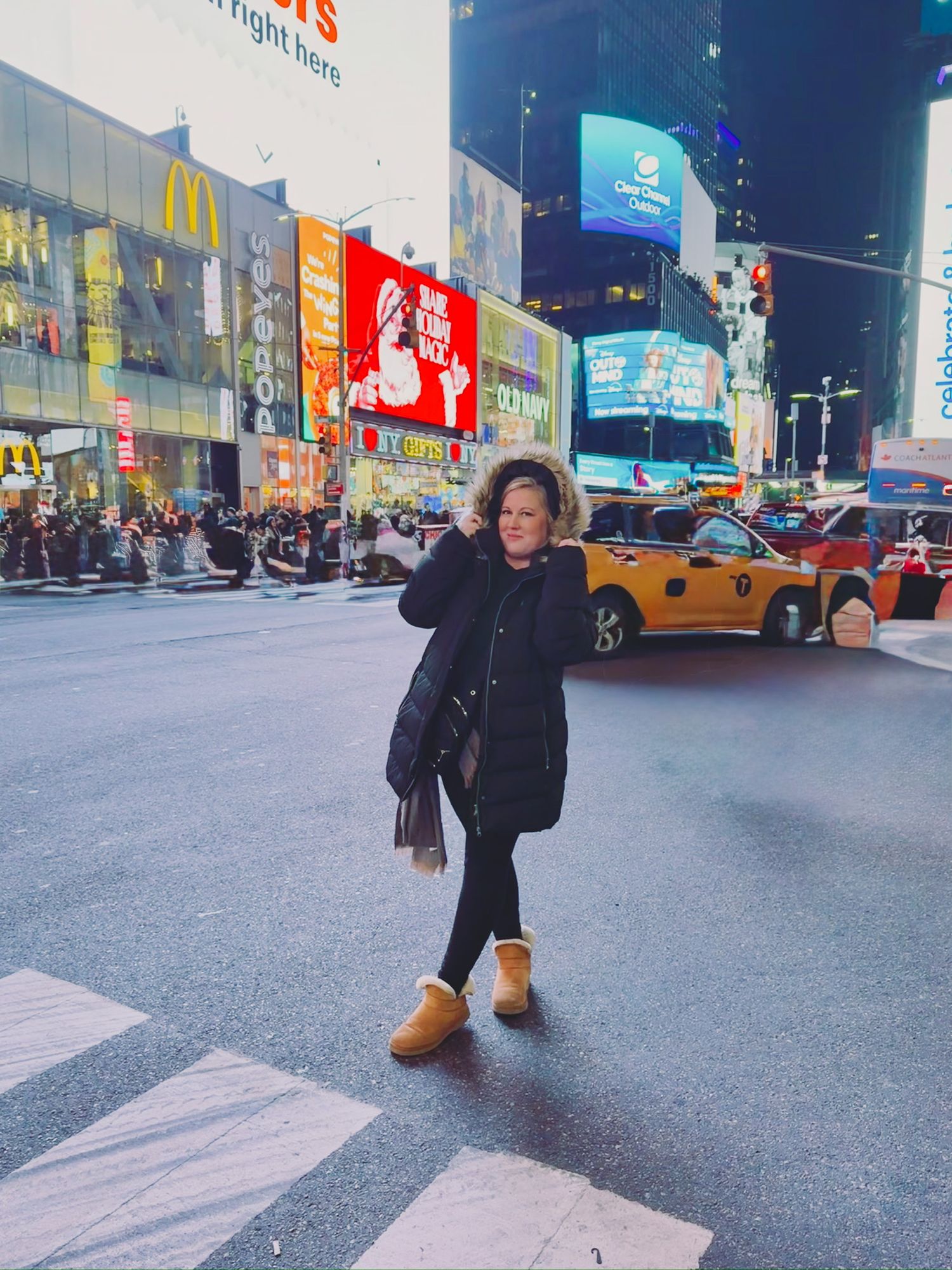 Urban street scene in Times Square with bright neon signs and billboards illuminating the city night.