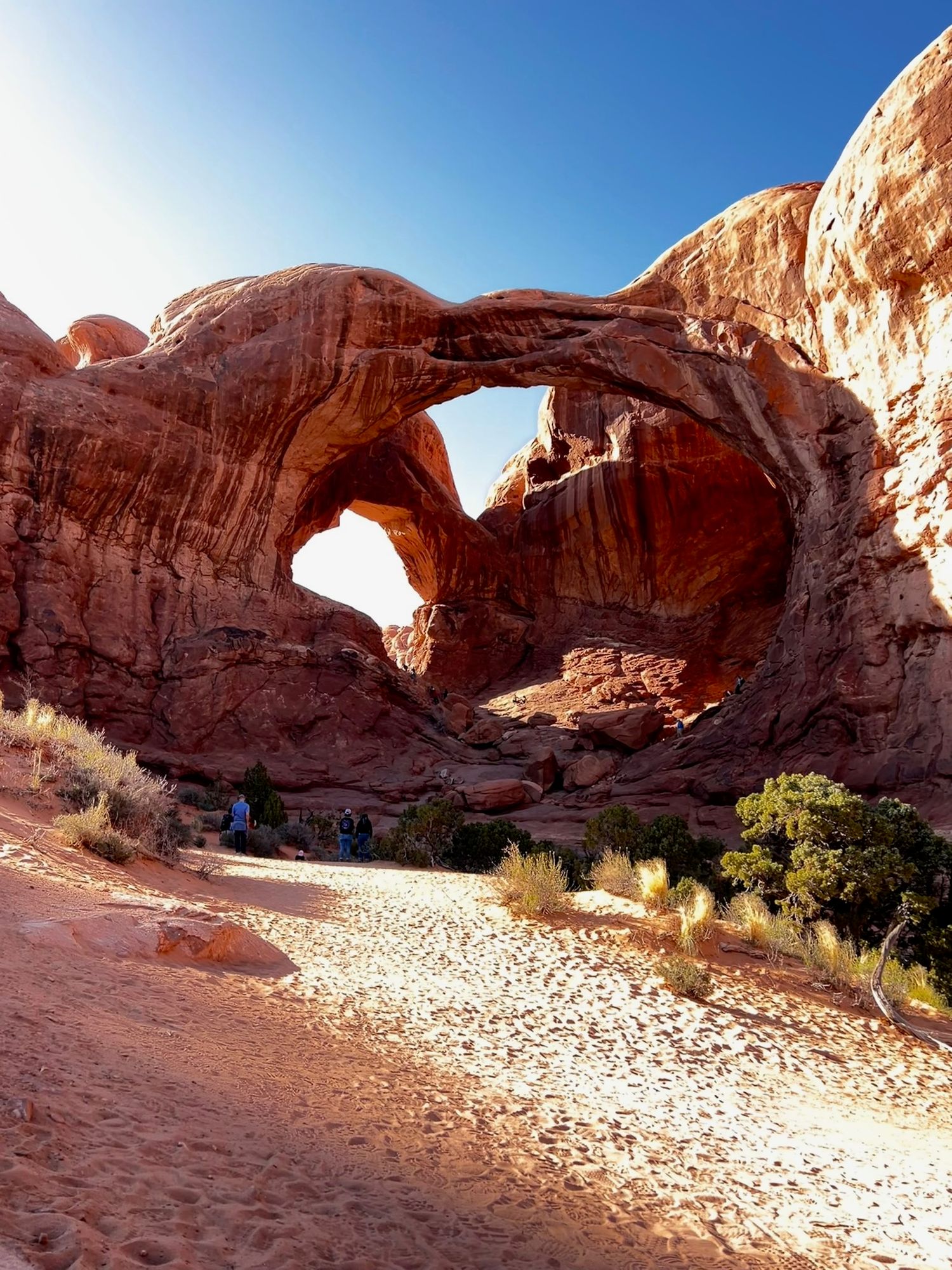 Natural stone arches span across desert landscape in Arches National Park.