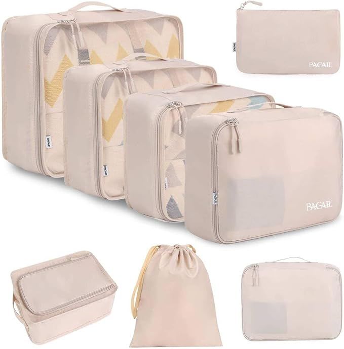 Set of beige packing cubes and toiletry bags arranged to show different sizes and organizational features for travel.