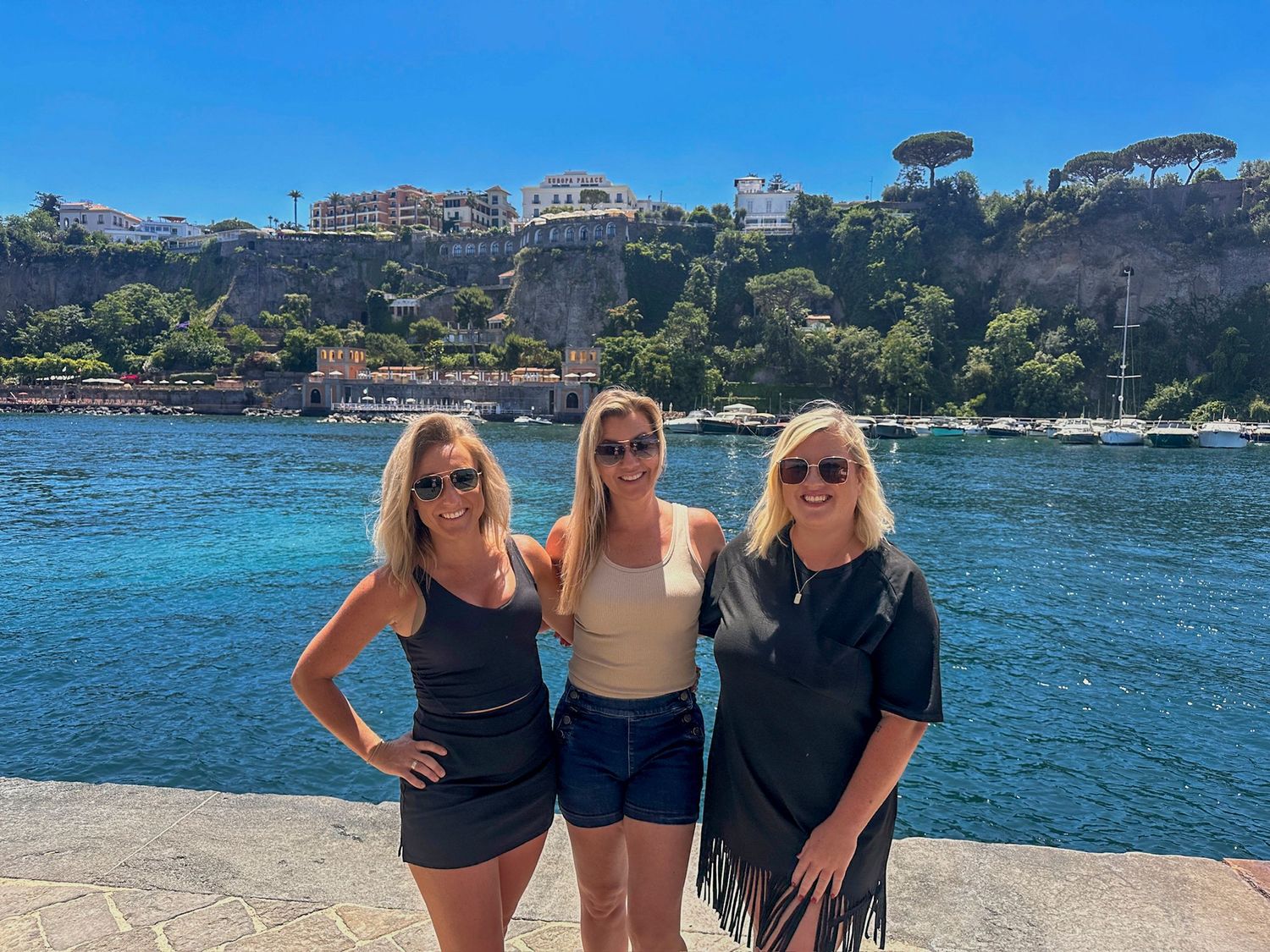 Scenic coastal view of Italian Mediterranean waterfront with buildings nestled on hillside.