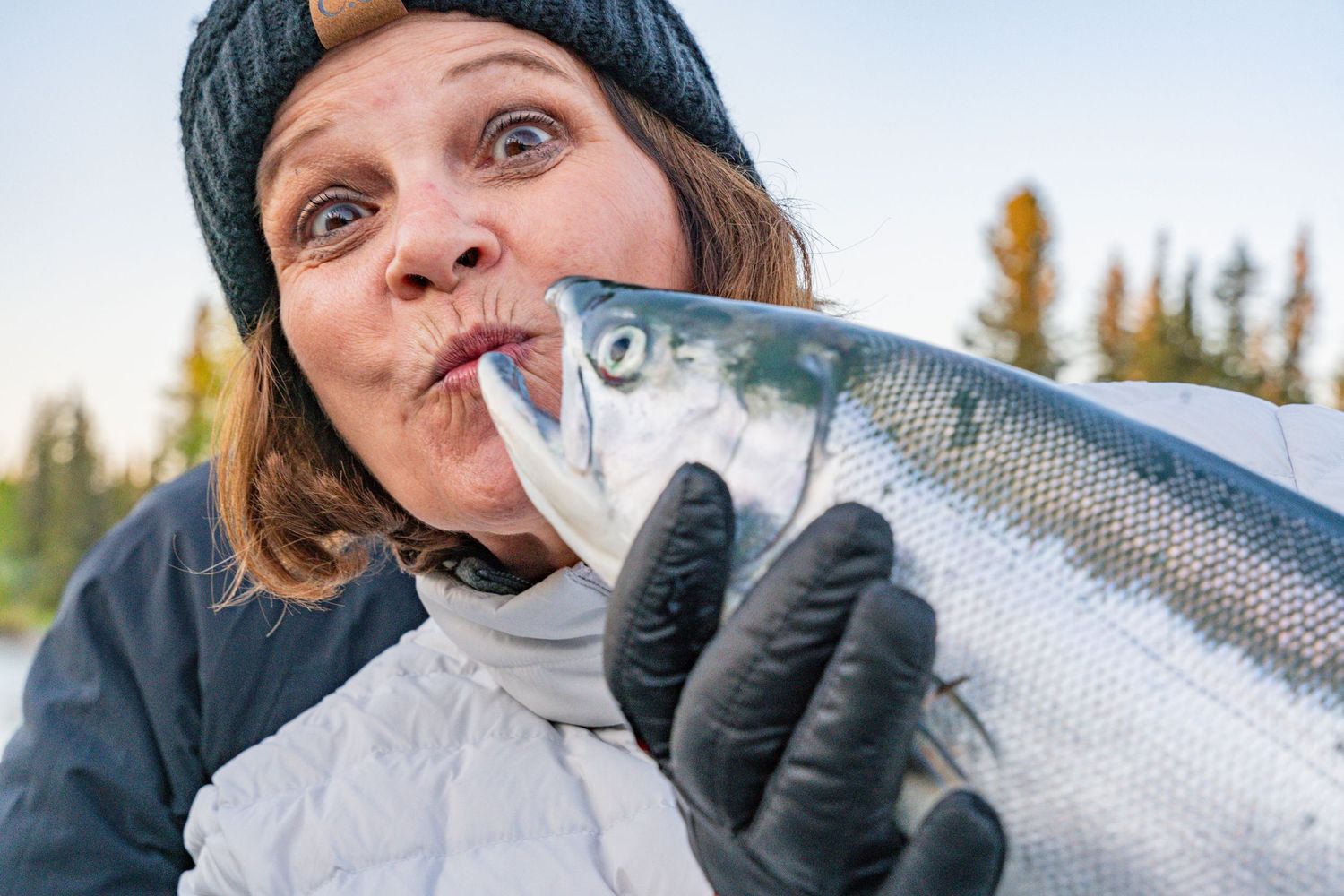 Adventure seekers display their fresh-caught salmon during an Alaskan fishing trip.