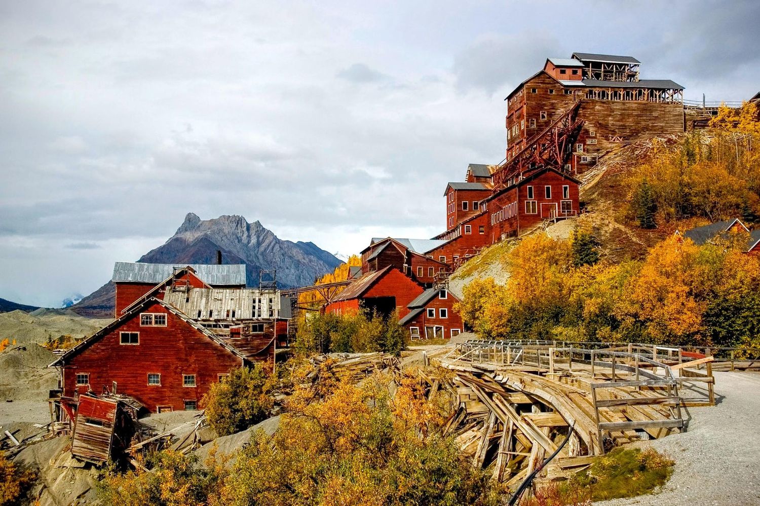 Abandoned Kennecott Copper Mine buildings set against autumn colors and mountain backdrop in Alaska.