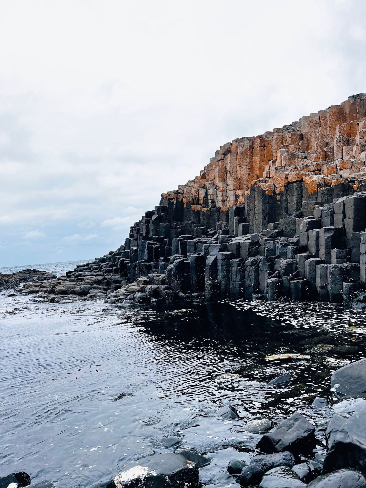 A panoramic view of the Giant's Causeway's hexagonal basalt columns along the rocky Northern Ireland coastline.