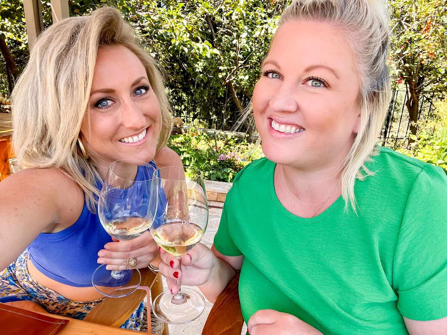 Outdoor wine tasting experience in a sunny garden setting.