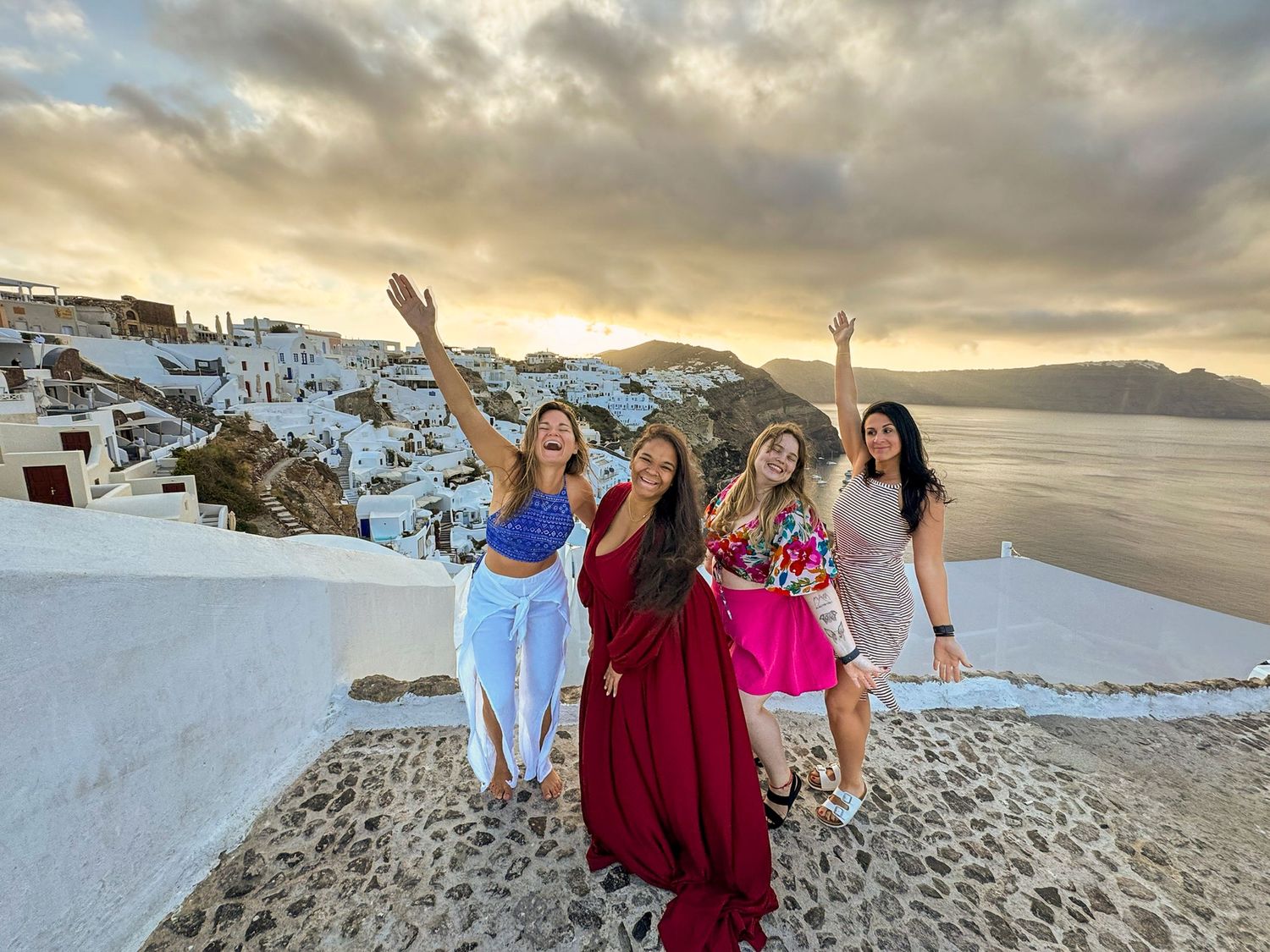 Scenic mountainous coastline at sunset with white buildings cascading down the cliffside.