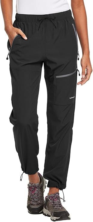 Black nylon cargo pants with drawstring legs shown on someone wearing gray hiking boots.