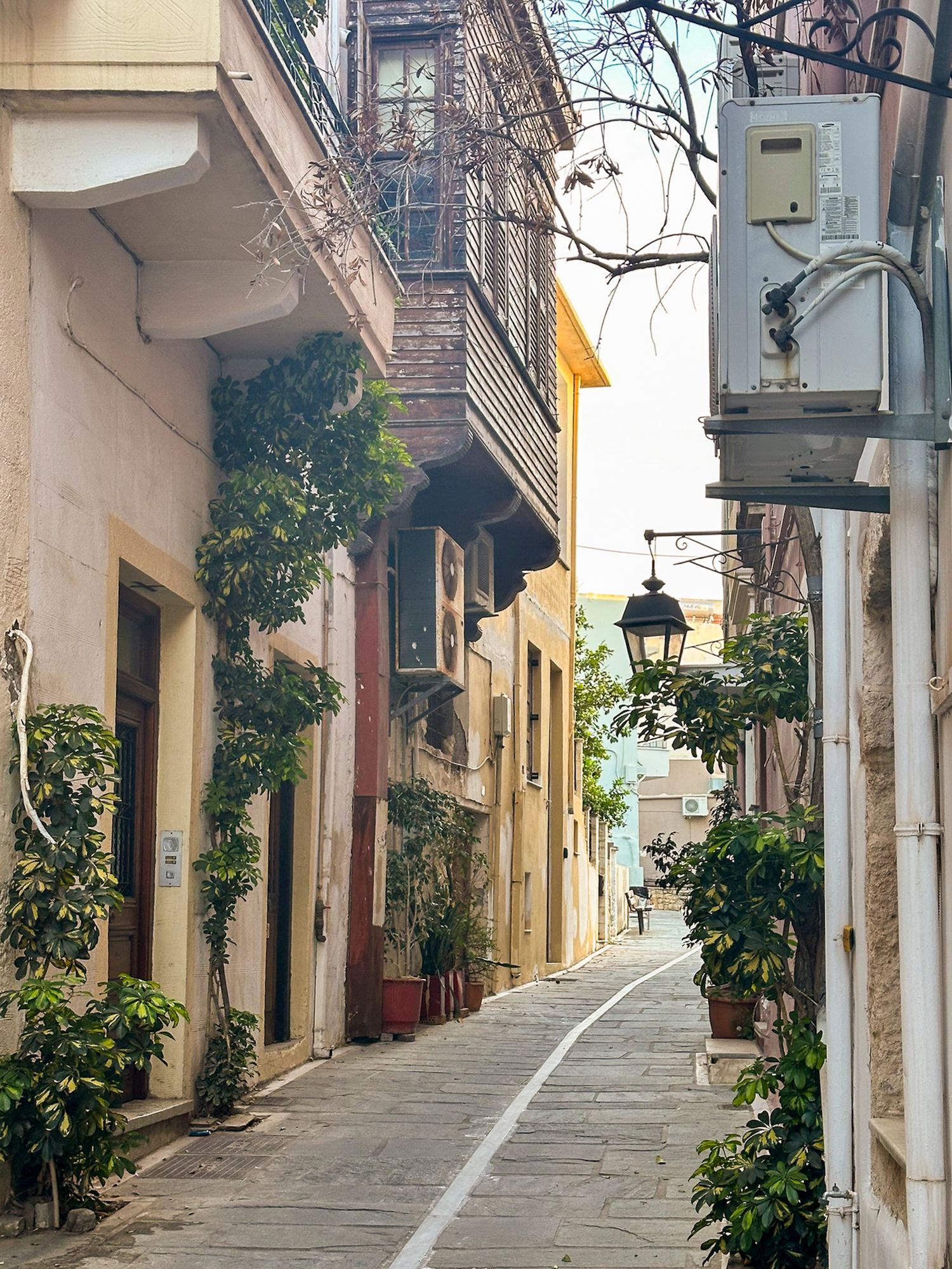 Charming narrow cobblestone street with traditional architecture and lanterns in European town.