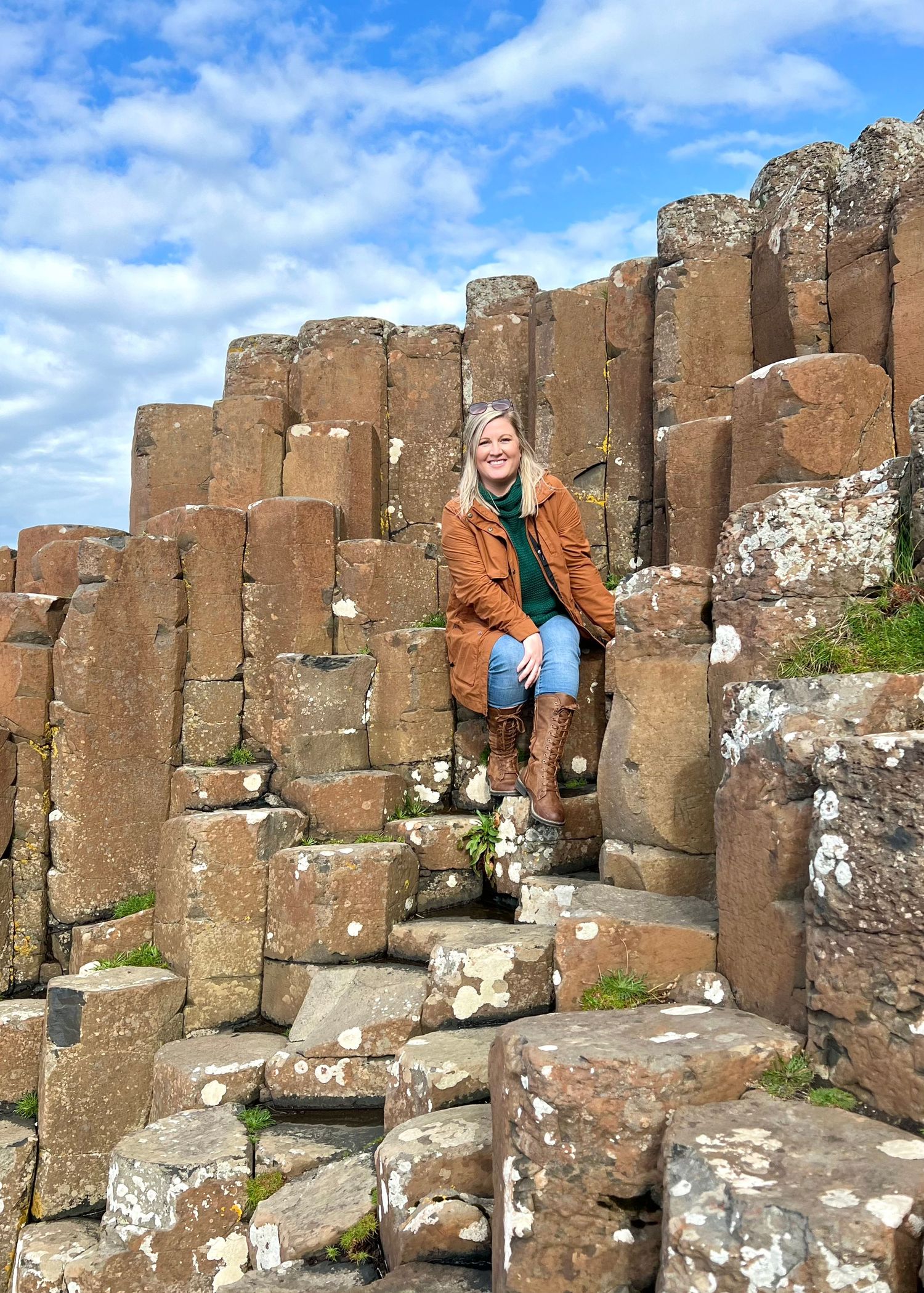 Panoramic view of the Giant's Causeway's iconic hexagonal basalt columns against a bright blue sky in Northern Ireland.