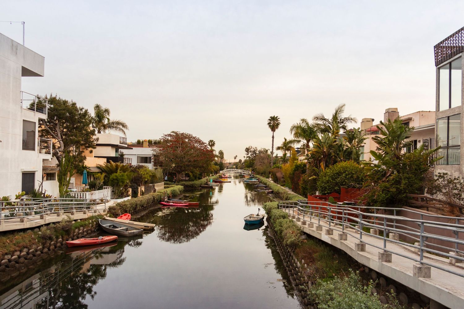 Panoramic view of a modern oceanfront property with white buildings and palm trees at sunset.