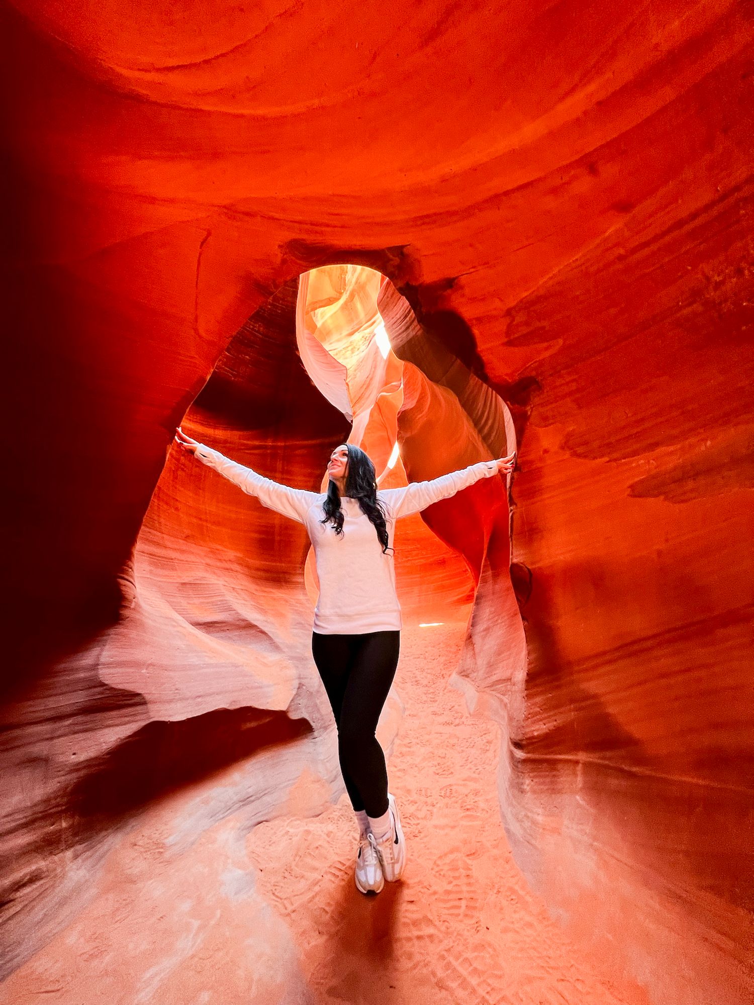 Silhouettes of visitors against vibrant red canyon walls in Antelope Canyon.