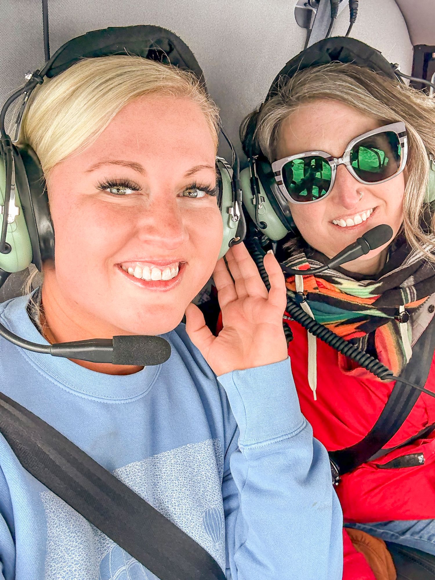 Helicopter passengers take joyful selfies during a scenic flight adventure.
